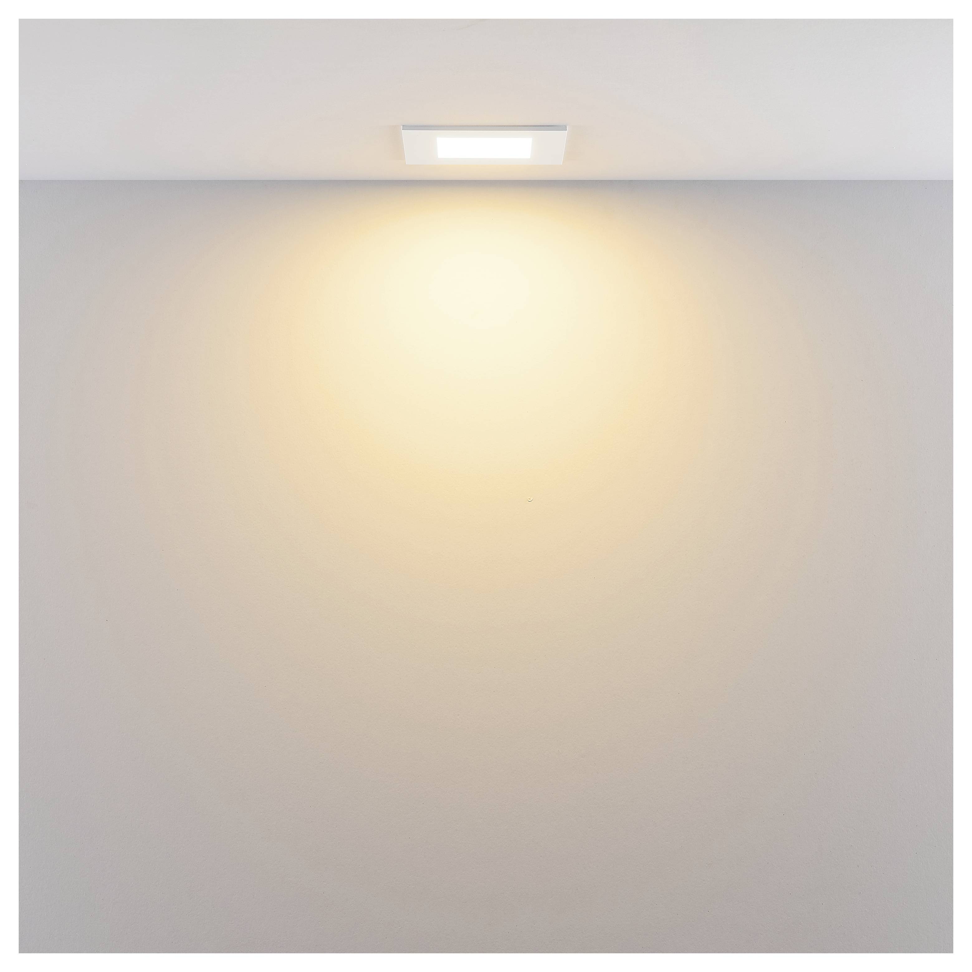 Eine an der Decke montierte Leuchte wirft ein warmes Licht auf eine schlichte weiße Wand und Decke.