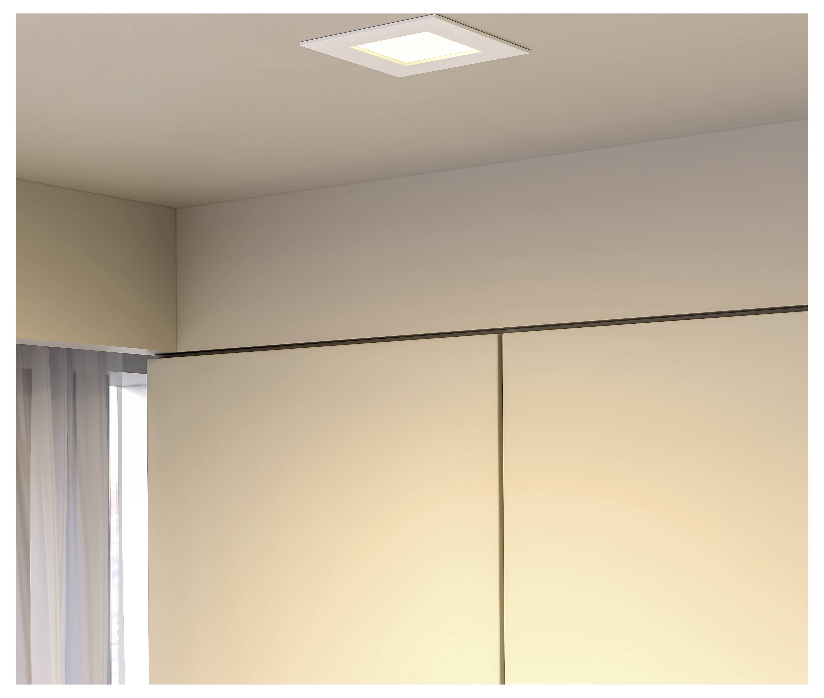 Deckenleuchte über beigen Wänden und einem Fenster mit transparenten Vorhängen in einem minimalistischen Raum.