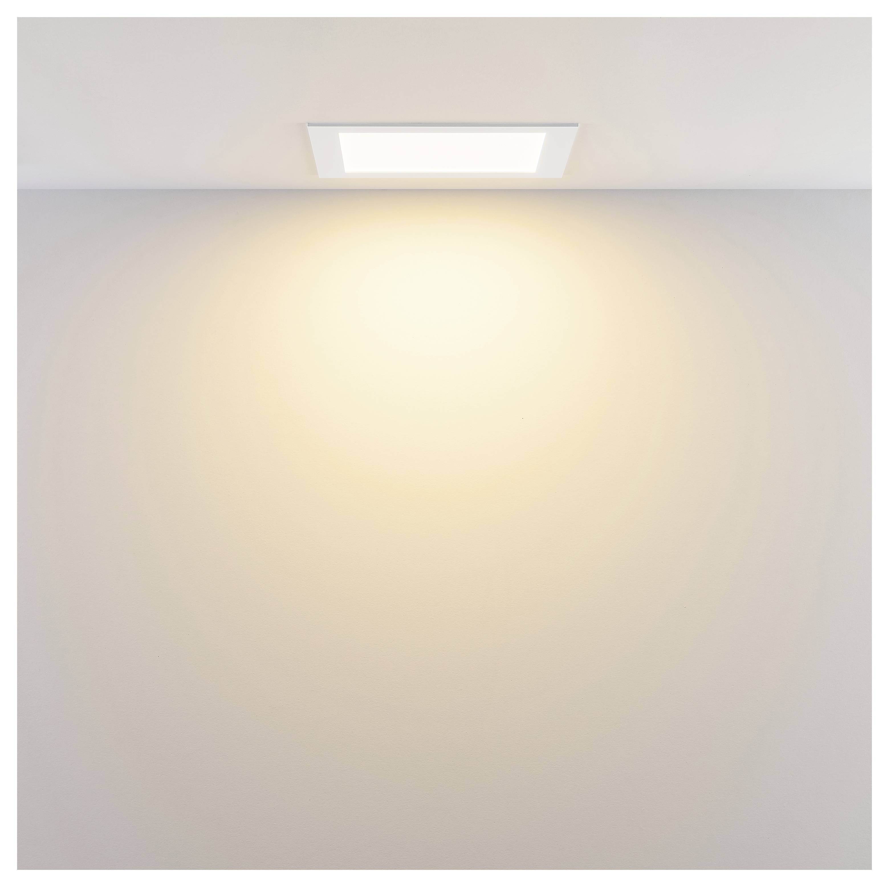 An der Decke montierte Einbauleuchte, die ein warmes Licht auf eine schlichte Wand wirft.
