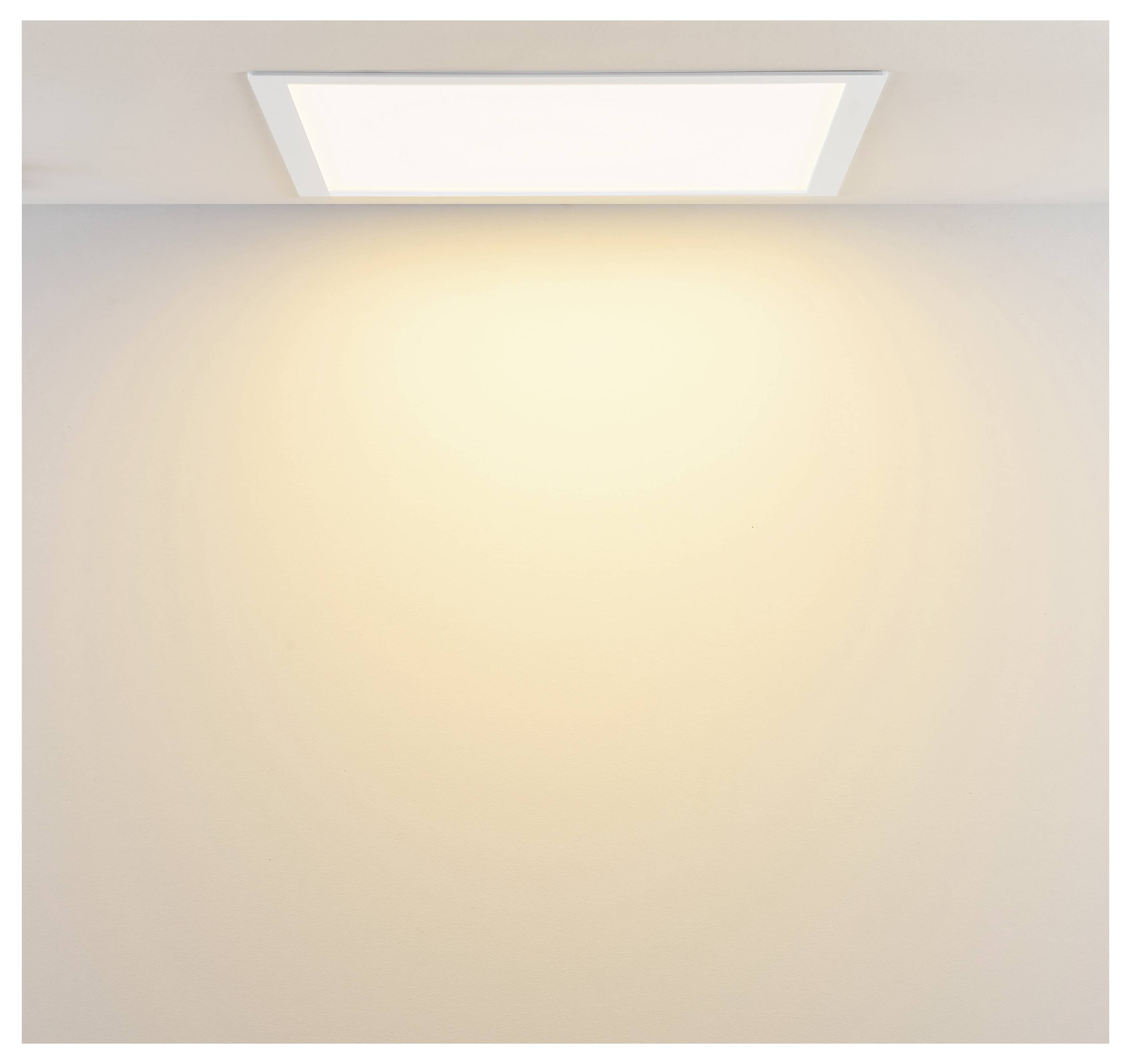 Deckeneinbauleuchte, die einen warmen Glanz auf eine leere Wand wirft.