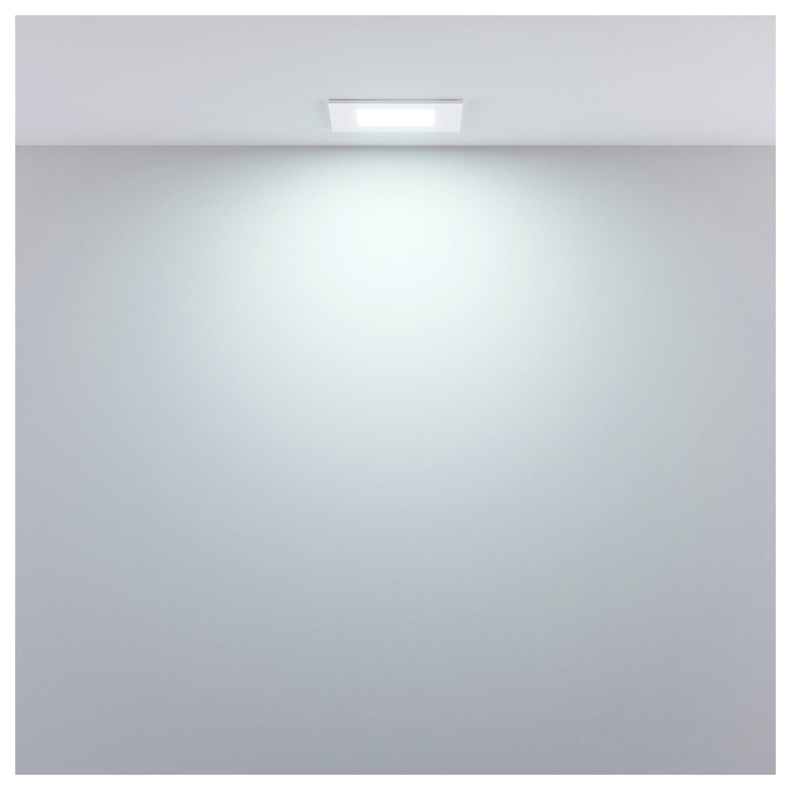 Leeres Zimmer mit einer Wand, die von einer hellen Deckenleuchte beleuchtet wird, ohne sichtbare Menschen oder Möbel.