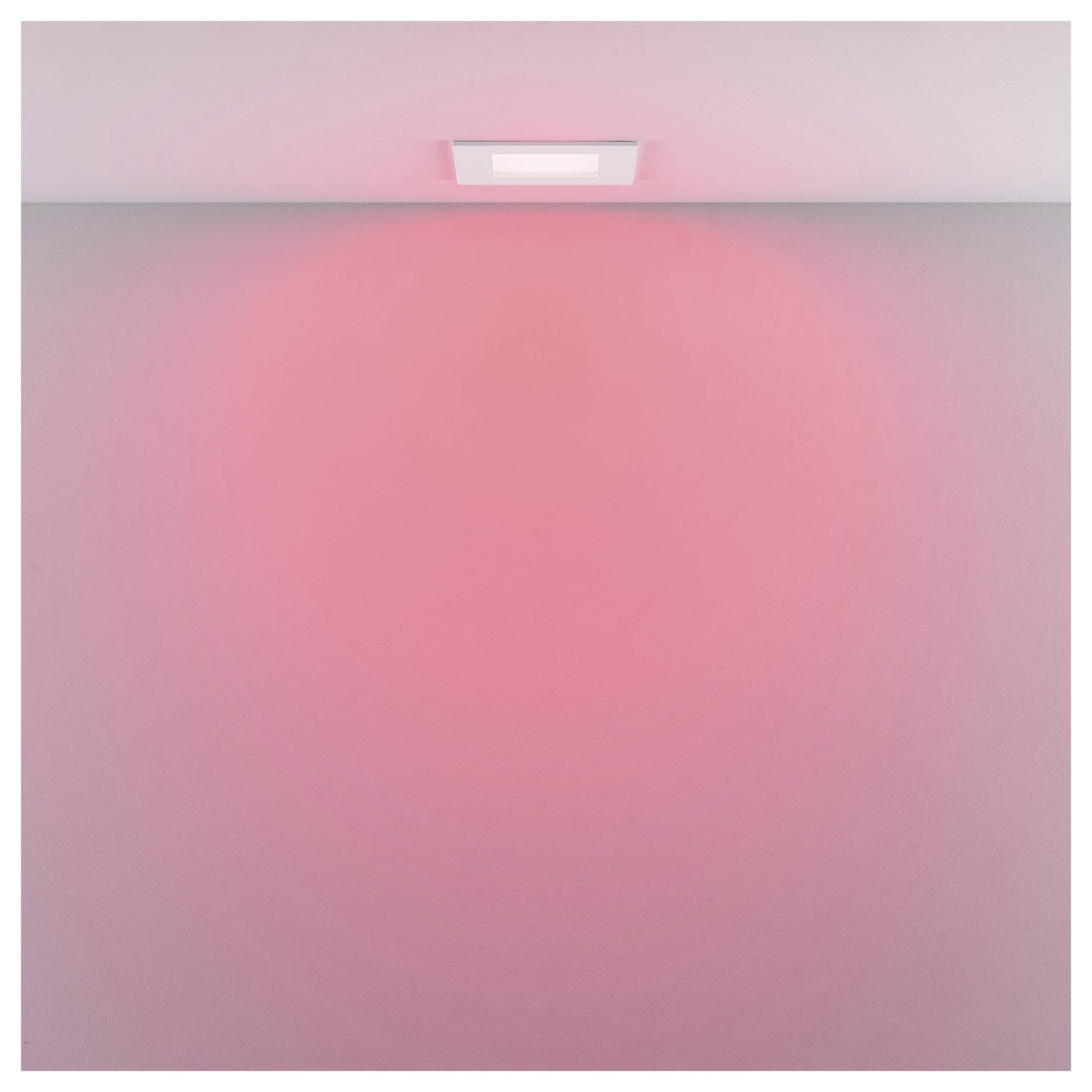 Ein Deckenleuchte wirft ein weiches rosa Licht auf eine schlichte Wand und erzeugt damit einen einfachen Effekt der Umgebungsbeleuchtung.