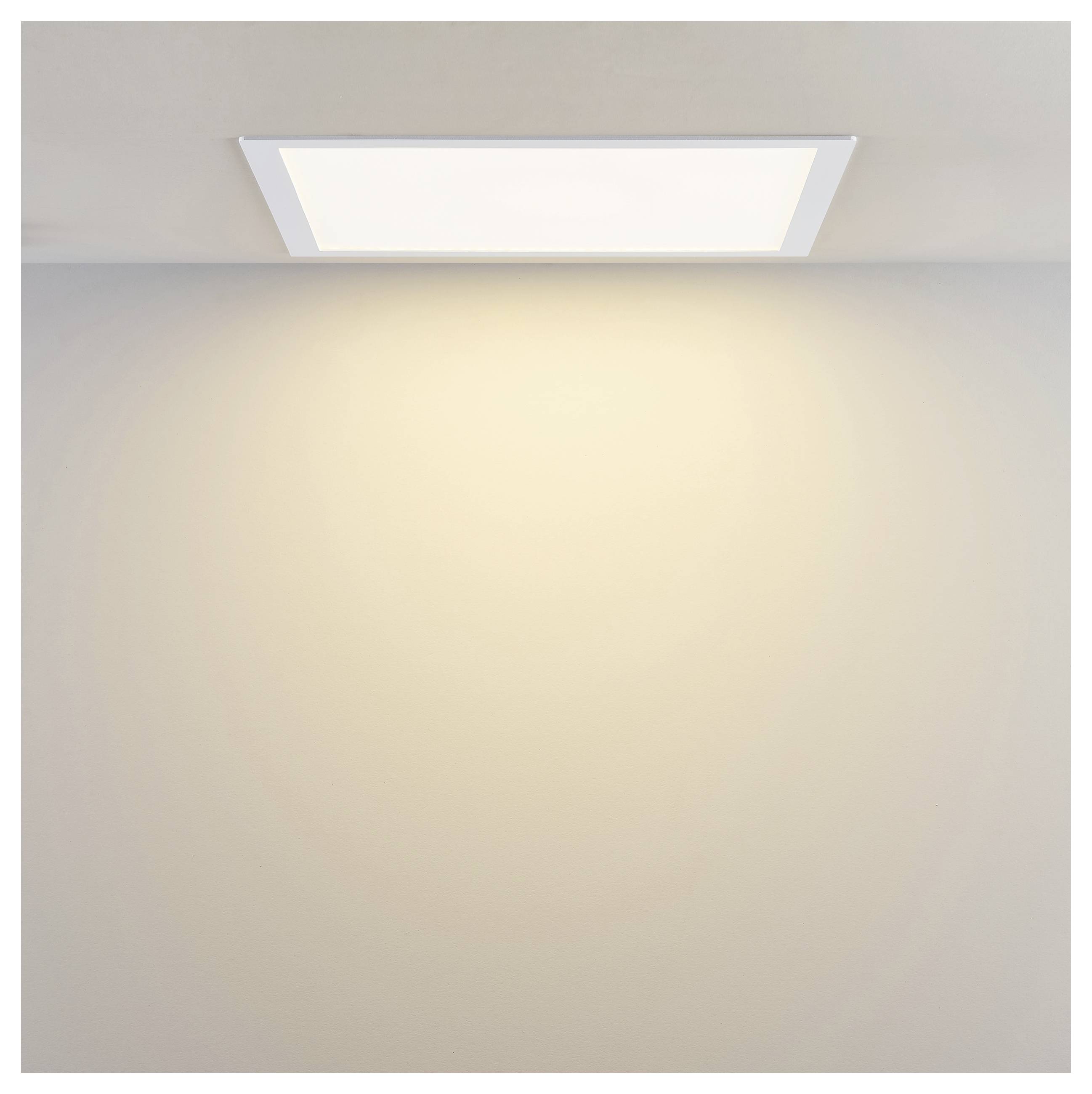 Quadratische Einbauleuchte in der Decke, die ein warmes Licht auf eine schlichte Wand wirft.