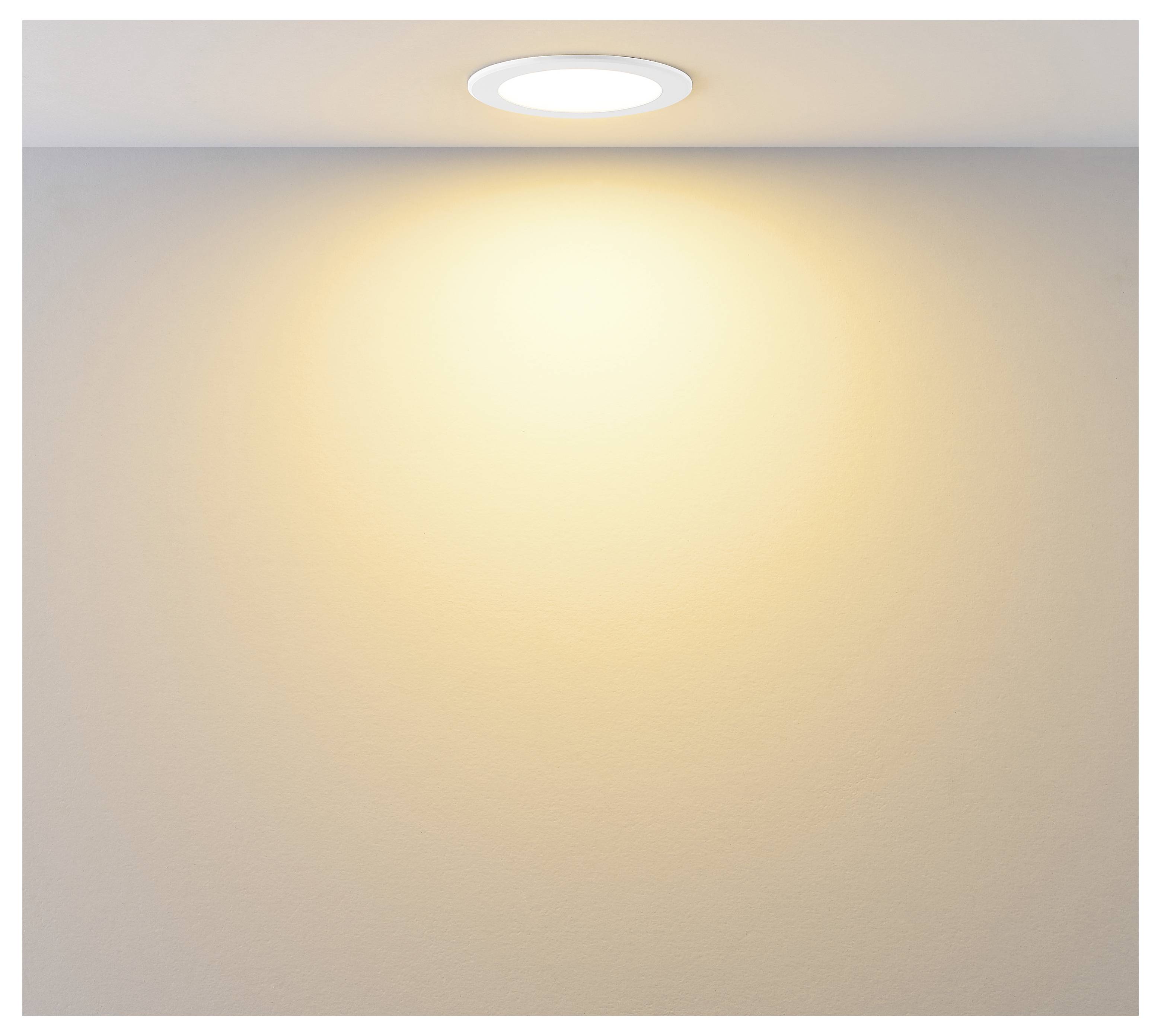 An der Decke angebrachte runde Leuchte, die einen warmen, zentrierten Lichtschein auf eine schlichte beige Wand wirft.