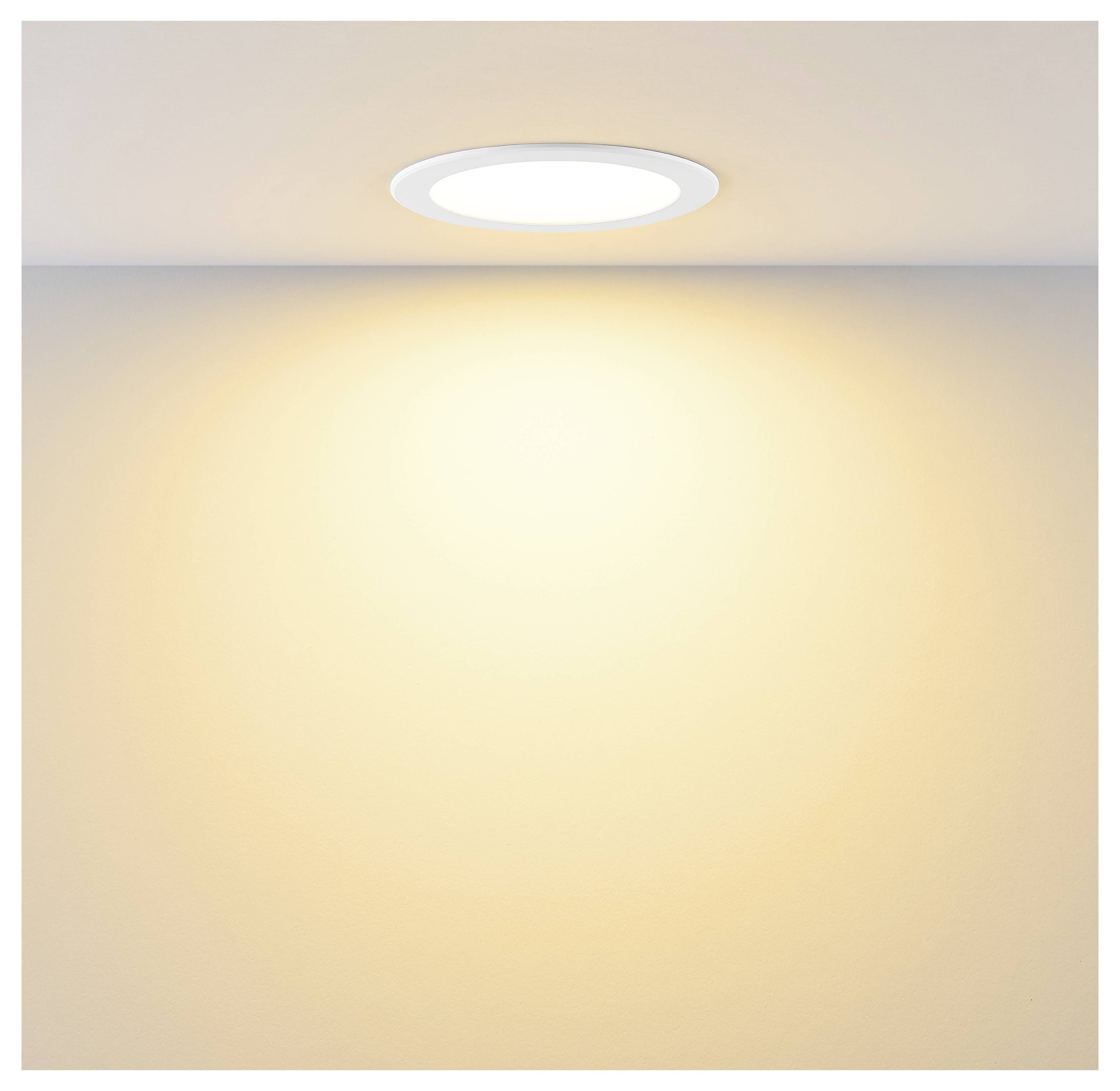 Runde, versenkte Deckenleuchte, die einen warmen, hellen Glanz auf eine schlichte beige Wand wirft.