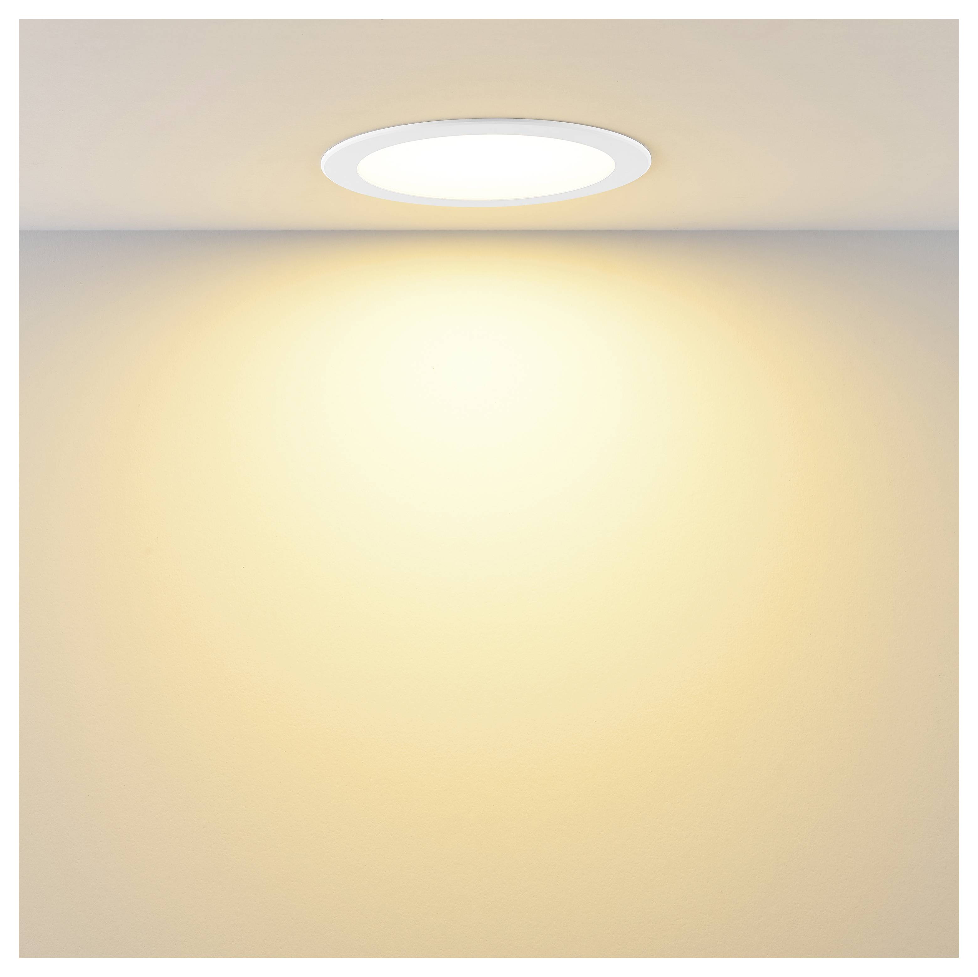 Rundes, bündig eingebautes Deckenleuchte, die warm leuchtet und einen weichen, hellen Lichtkegel auf die Wand darunter wirft.
