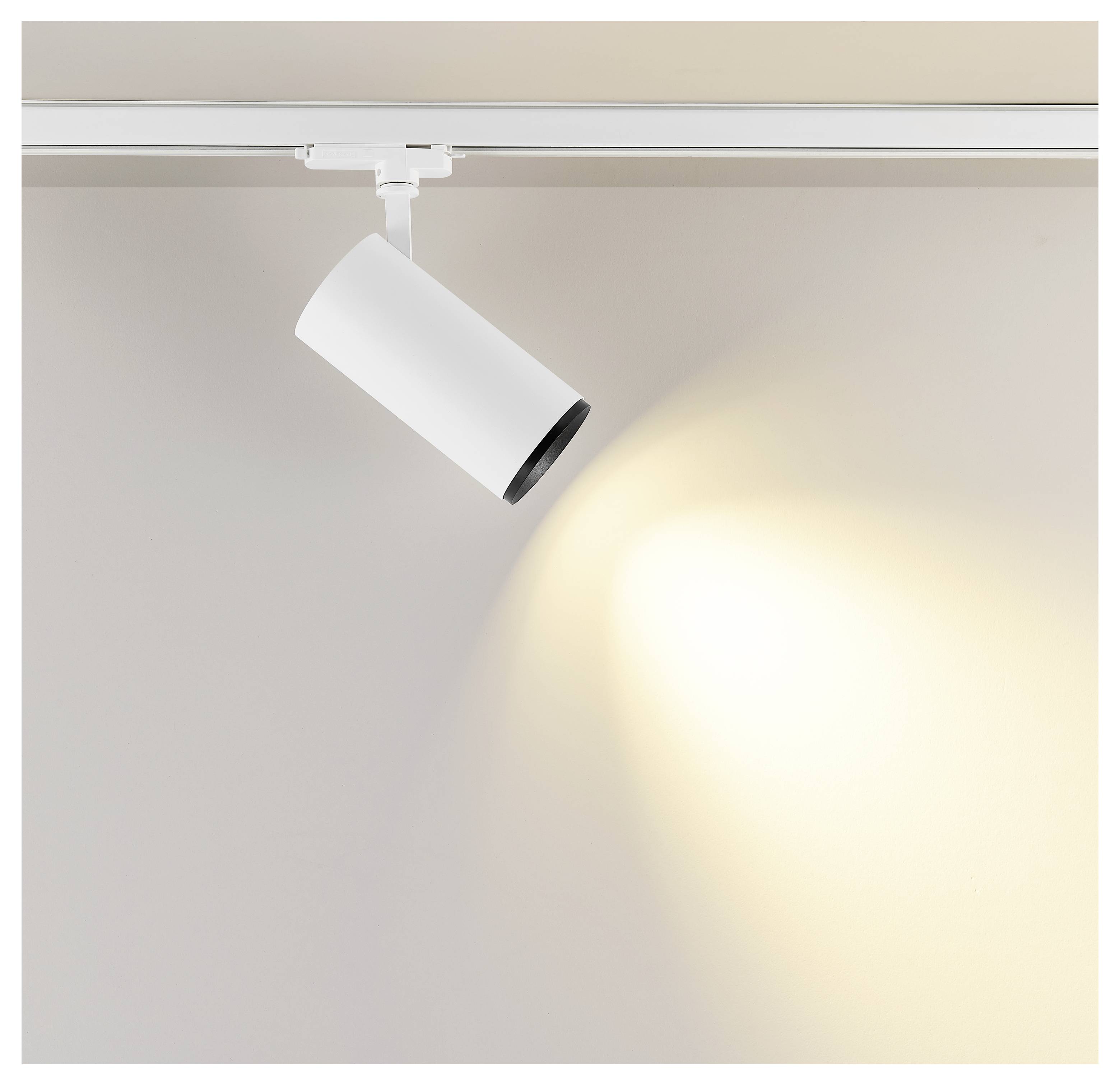 Weißer schienenmontierter Scheinwerfer, auf eine Wand gerichtet und wirft einen warmen ovalen Lichtstrahl.