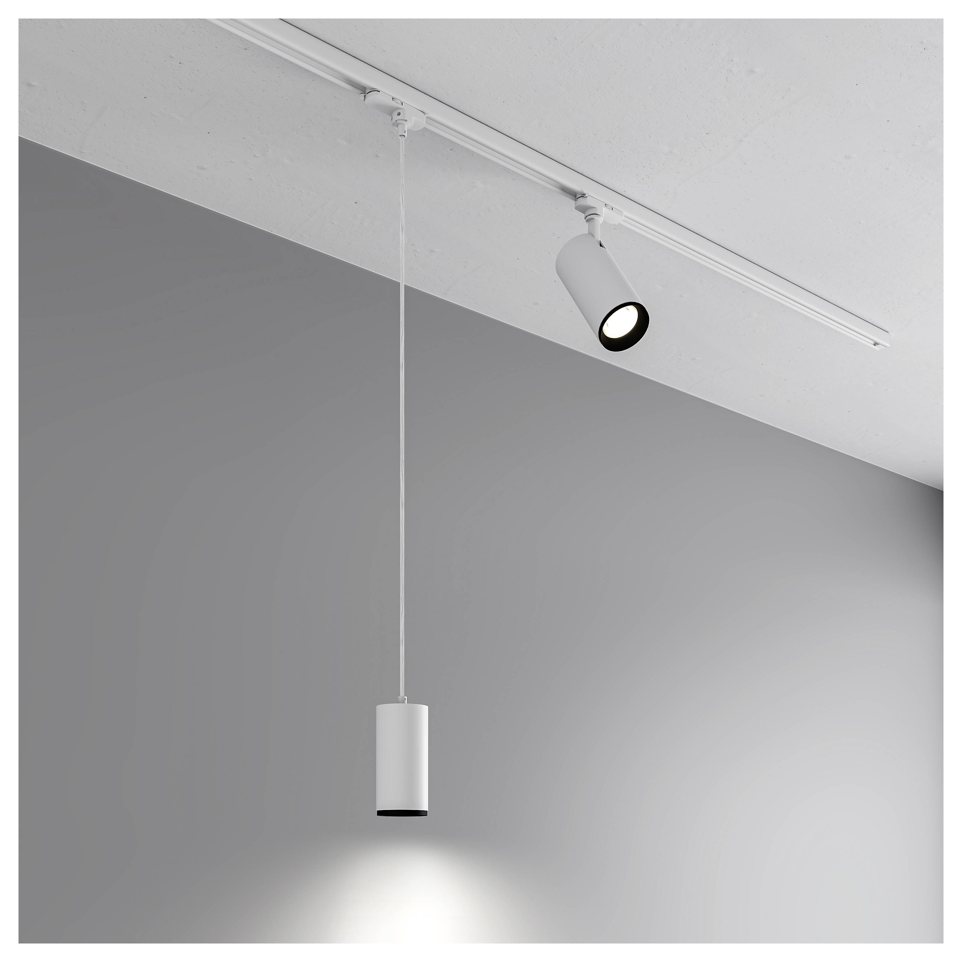 Minimalistischer Deckenspot und hängende Pendelleuchte, die eine graue Wand beleuchten.
