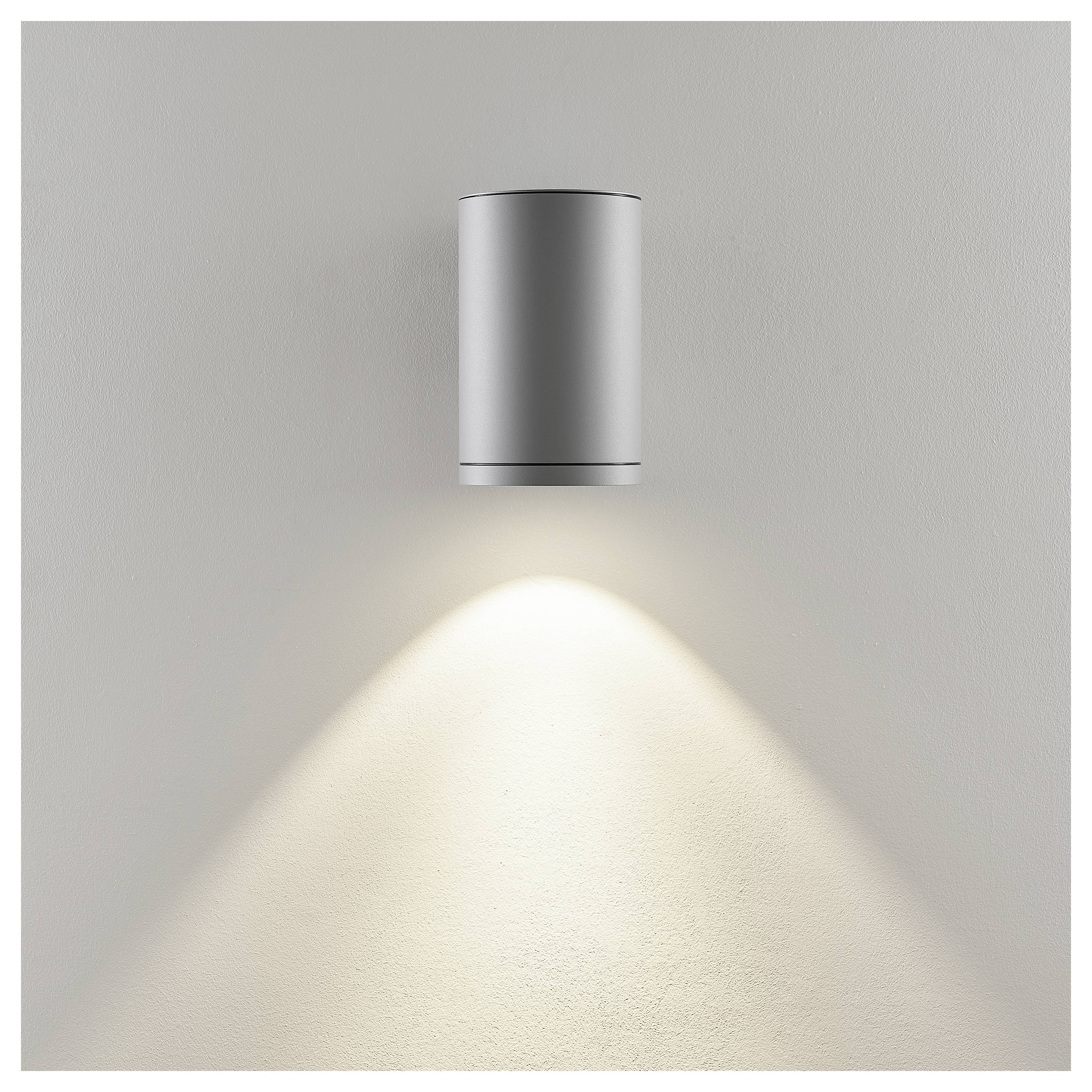 Minimalistische Wandleuchte, die einen sanften Lichtkegel auf eine schlichte Wand wirft.