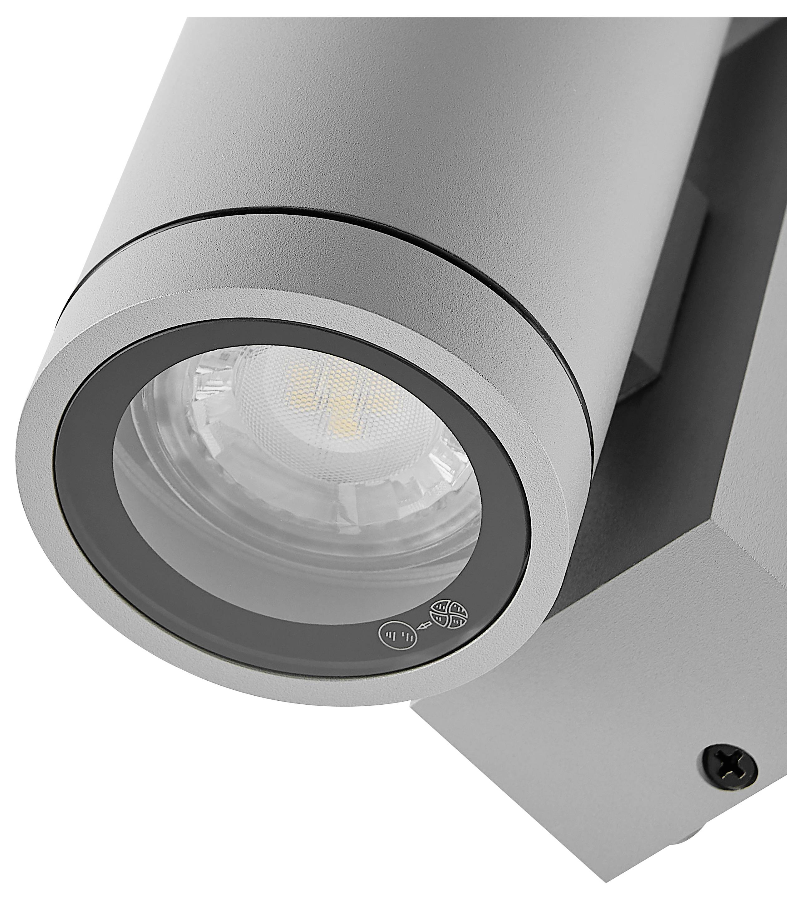 Nahaufnahme eines silbernen verstellbaren LED-Spotlichts auf einer Wandhalterung, das den Lampenkopf und die kreisförmige Linse zeigt.