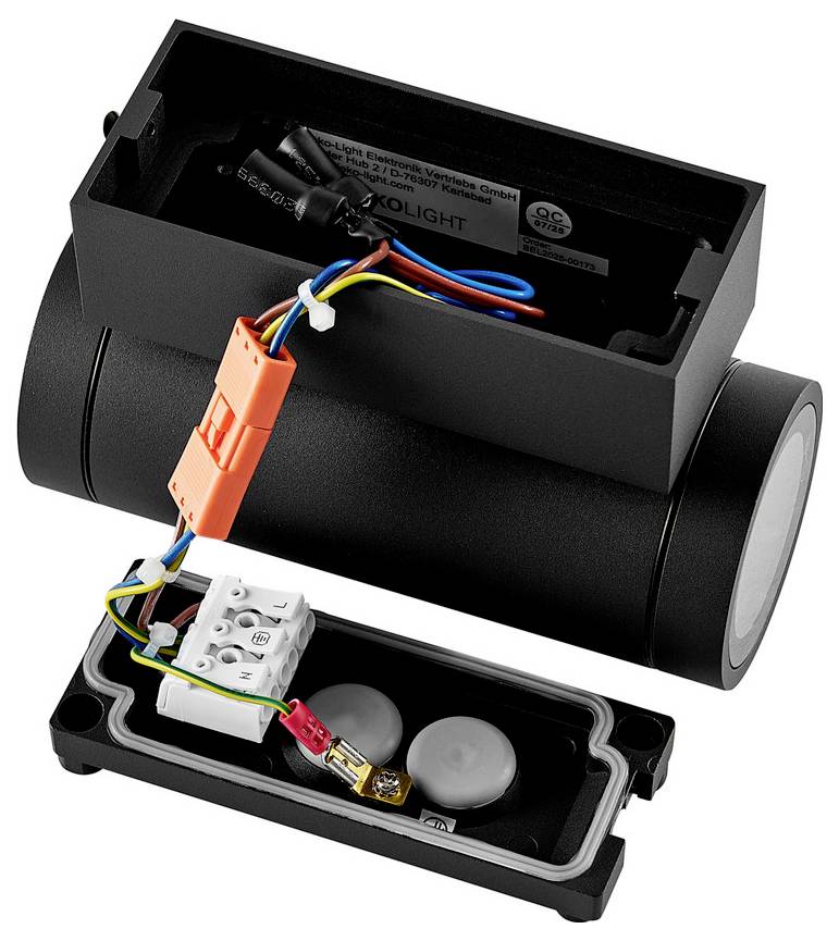 Offene schwarze zylindrische Elektrolichtleuchte mit entferntem Gehäuse, die interne Verdrahtung, einen orangefarbenen Stecker und eine Klemmleiste in einem separaten Basiskompartiment zeigt.