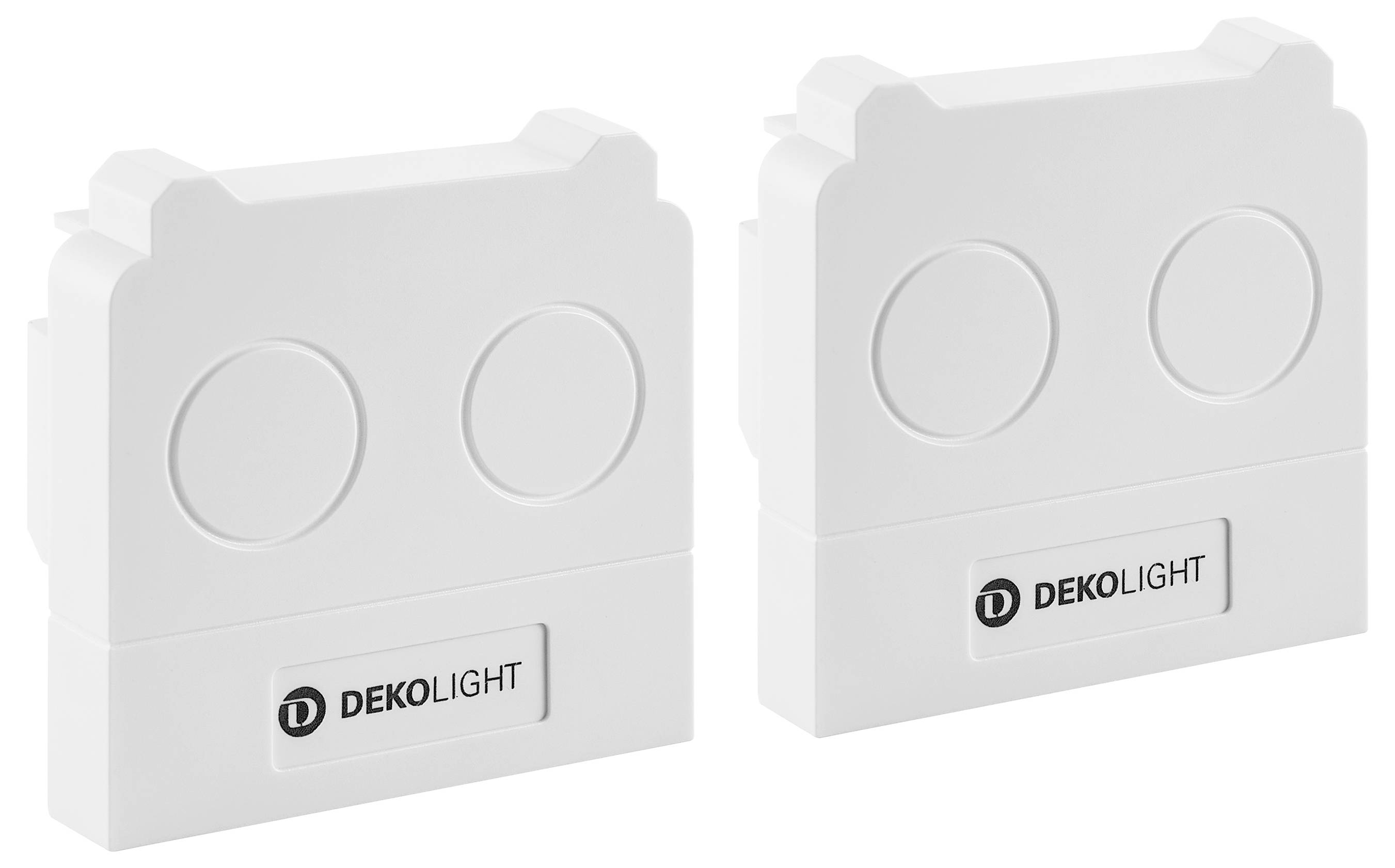 Zwei weiße DEKOLIGHT-Leuchten oder Montageelemente nebeneinander gezeigt, jedes mit zwei kreisförmigen Linsenbereichen und dem DEKOLIGHT-Logo.