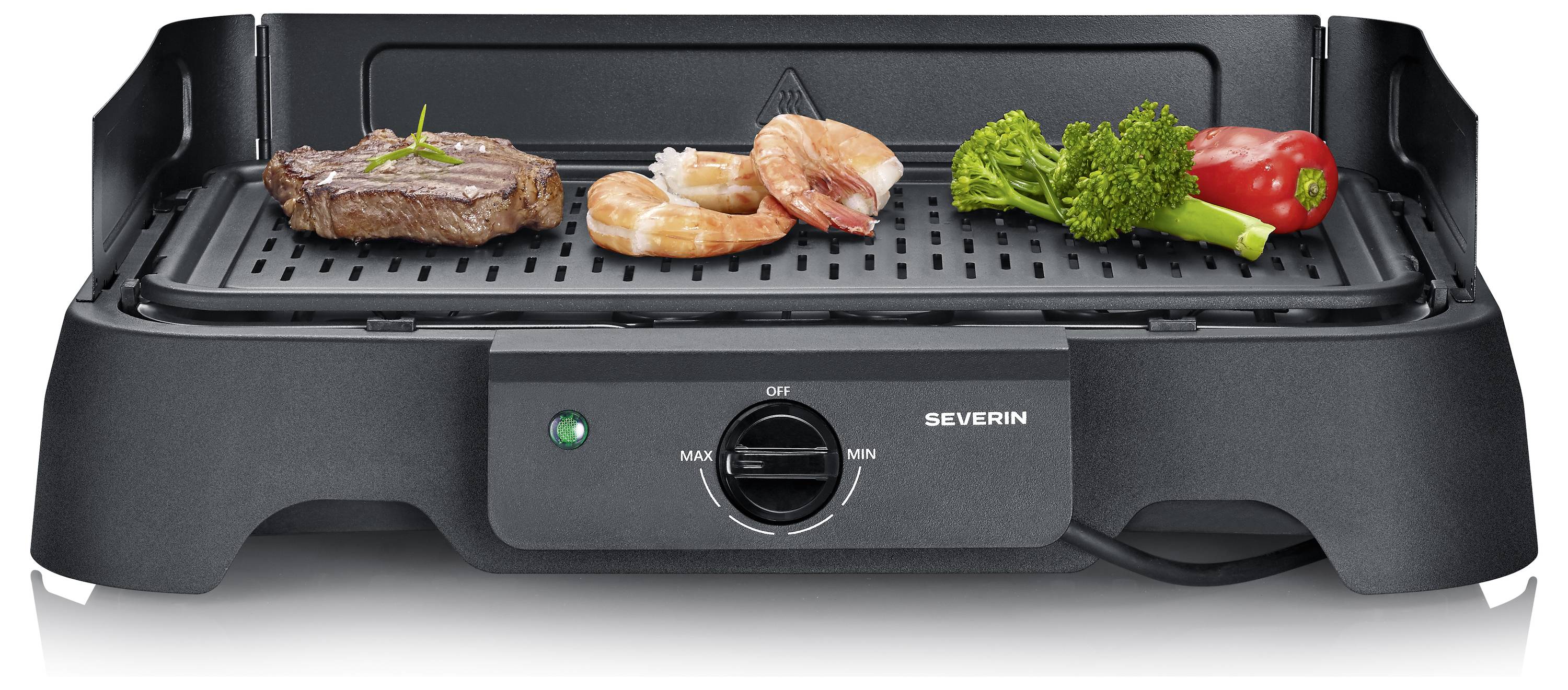 Schwarzer elektrischer Tischgrill mit Steak, Garnelen, Brokkoli und roter Paprika auf dem Rost