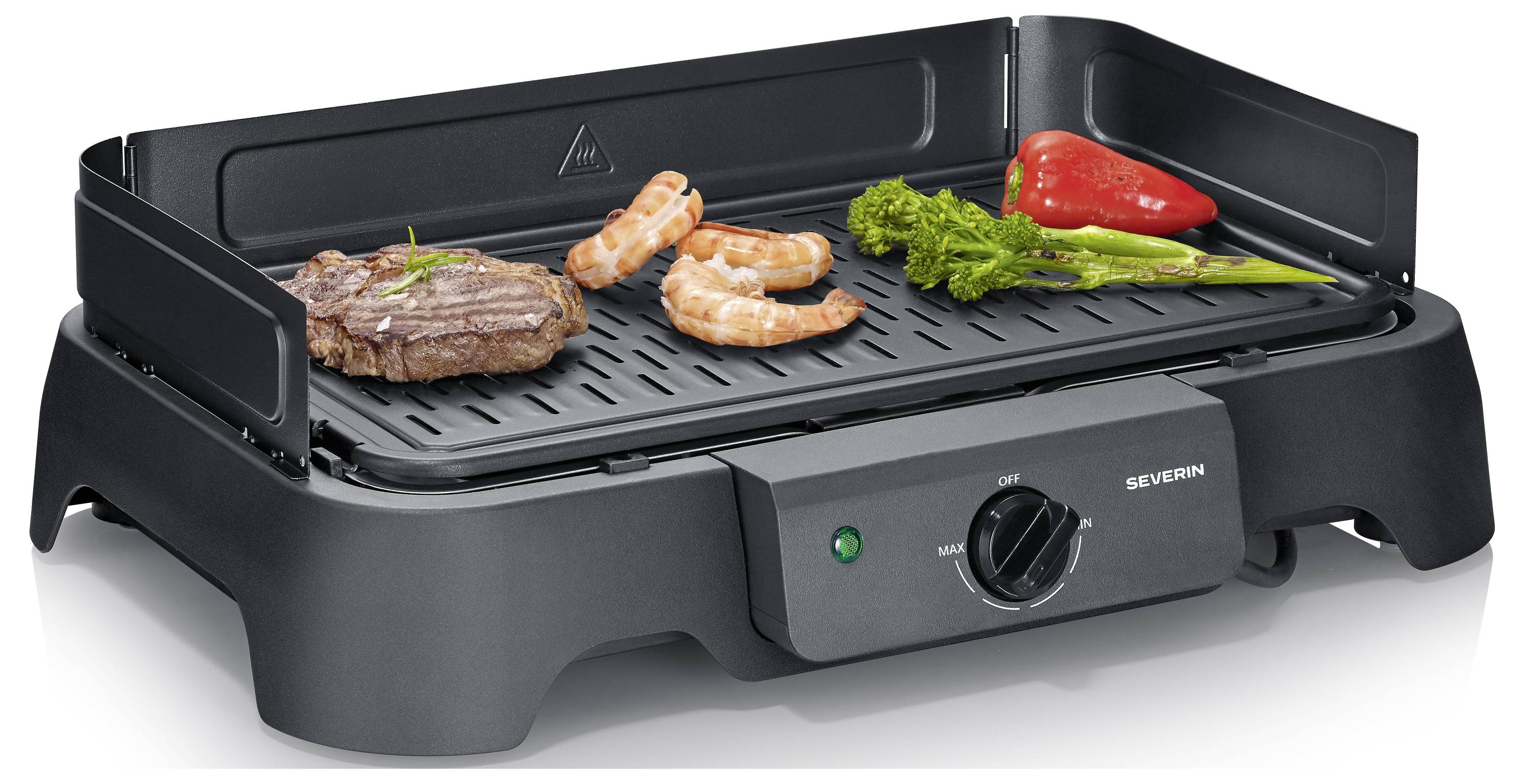 Elektrischer Tischgrill mit einem Steak, Garnelen, Brokkoli und roter Paprika auf dem gerippten Grillrost.