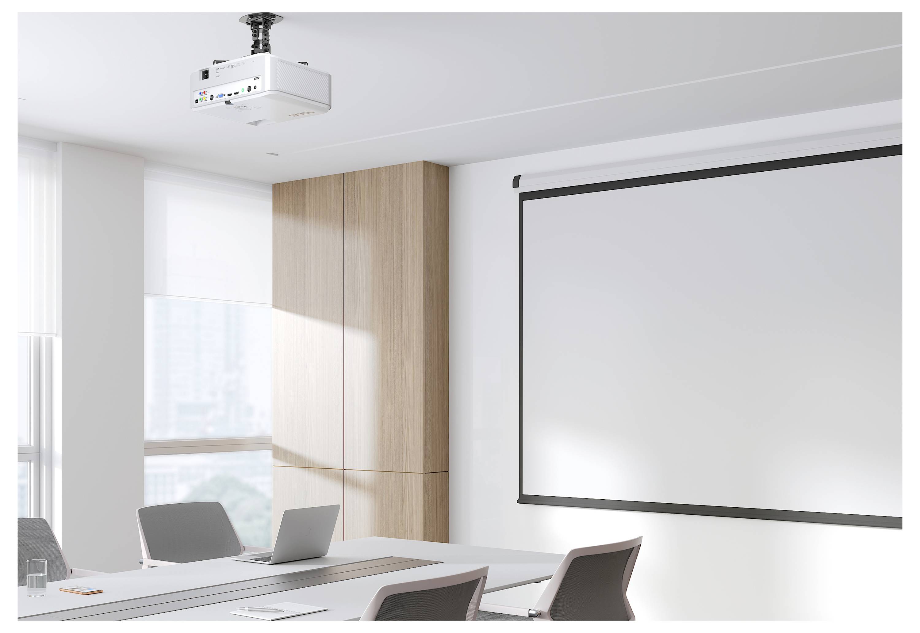 Modernes Konferenzzimmer mit an der Decke montiertem Projektor, der auf eine leere Herunterklapp-Leinwand gerichtet ist, Tisch, Stühle und Laptop.