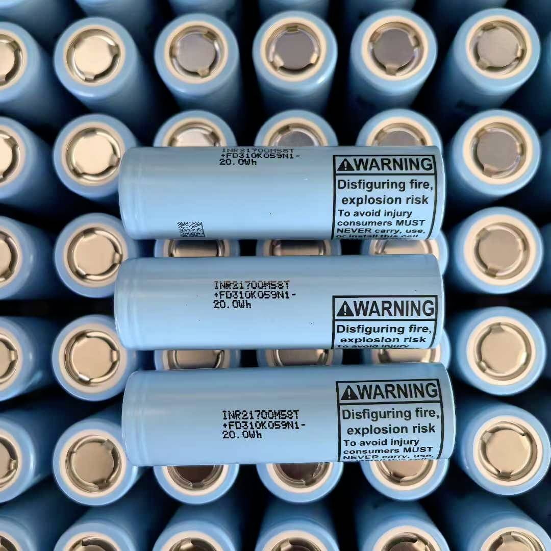 Nahaufnahme von gestapelten blauen Lithium-Ionen-Batterien mit Warnzetteln über Brand- und Explosionsrisiko.