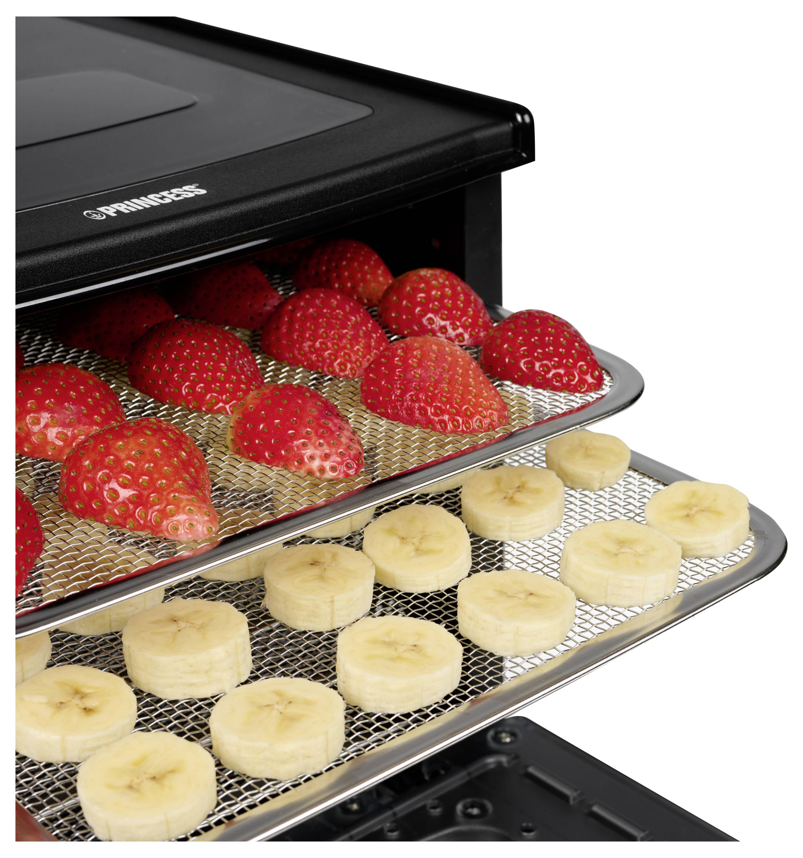 Lebensmitteltrockner mit Tabletts voller Erdbeeren und Bananenscheiben, die in einem schwarzen Gerät trocknen.