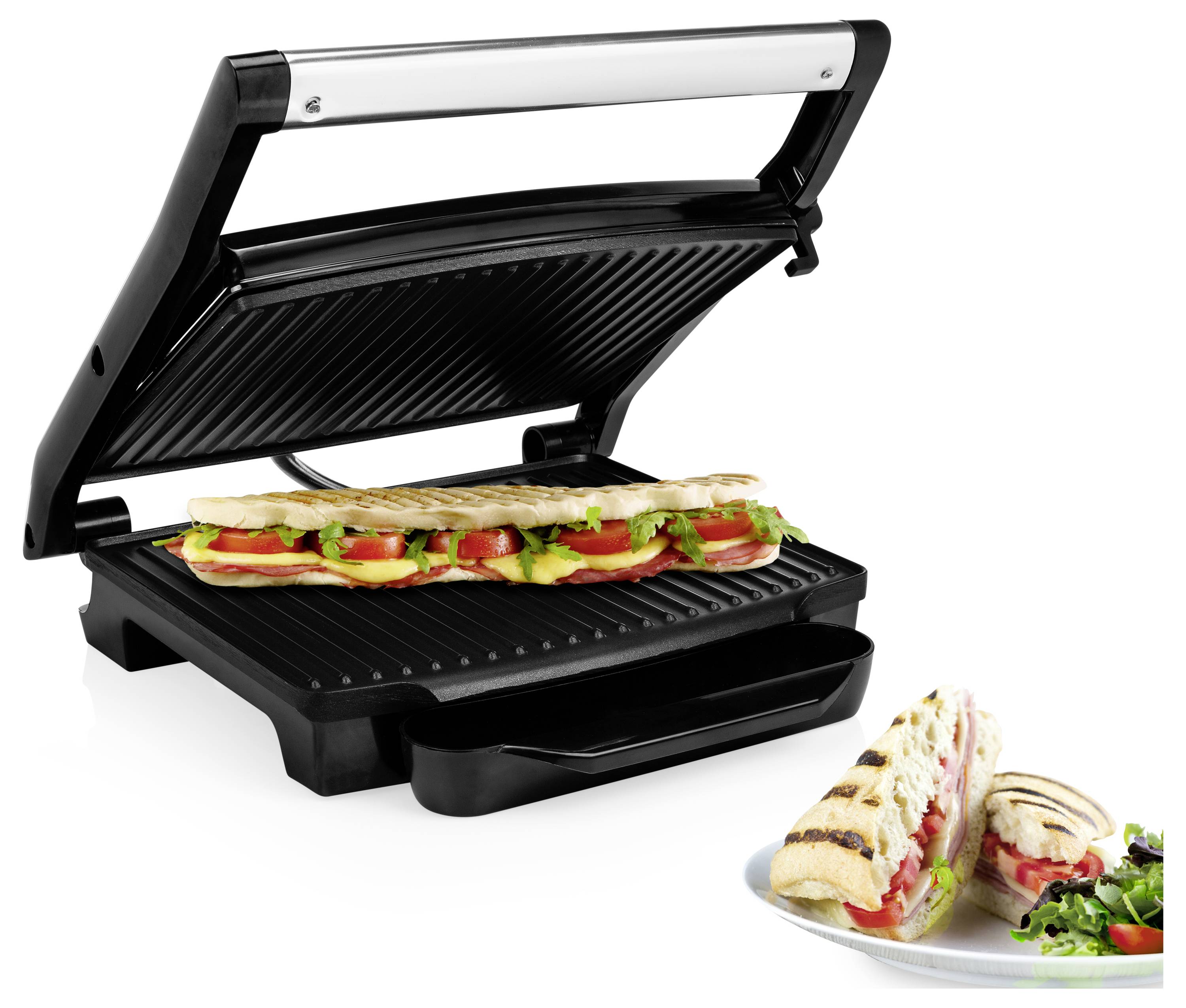 Offener Sandwichgrillpresse mit einem langen gerösteten Panini im Inneren; ein plattiertes geschnittenes Panini mit Salat und Tomaten sitzt daneben.