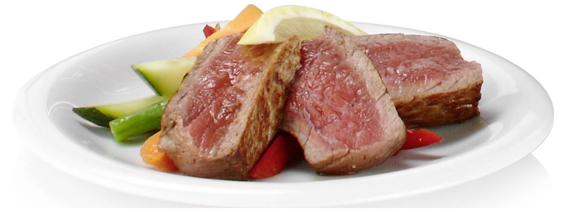 Geschnittenes mittelrares Steak serviert auf einem weißen Teller mit Gemüse, einschließlich Spargel, Möhren und Zucchini.