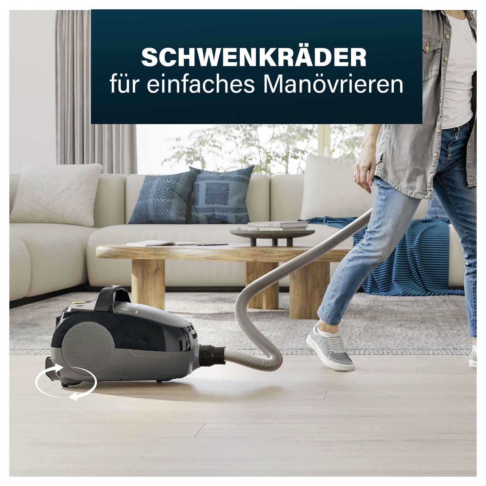 Staubsauger mit Schwenkrädern in modernem Wohnzimmer; Text: 'SCHWENKRÄDER für einfaches Manövrieren'.