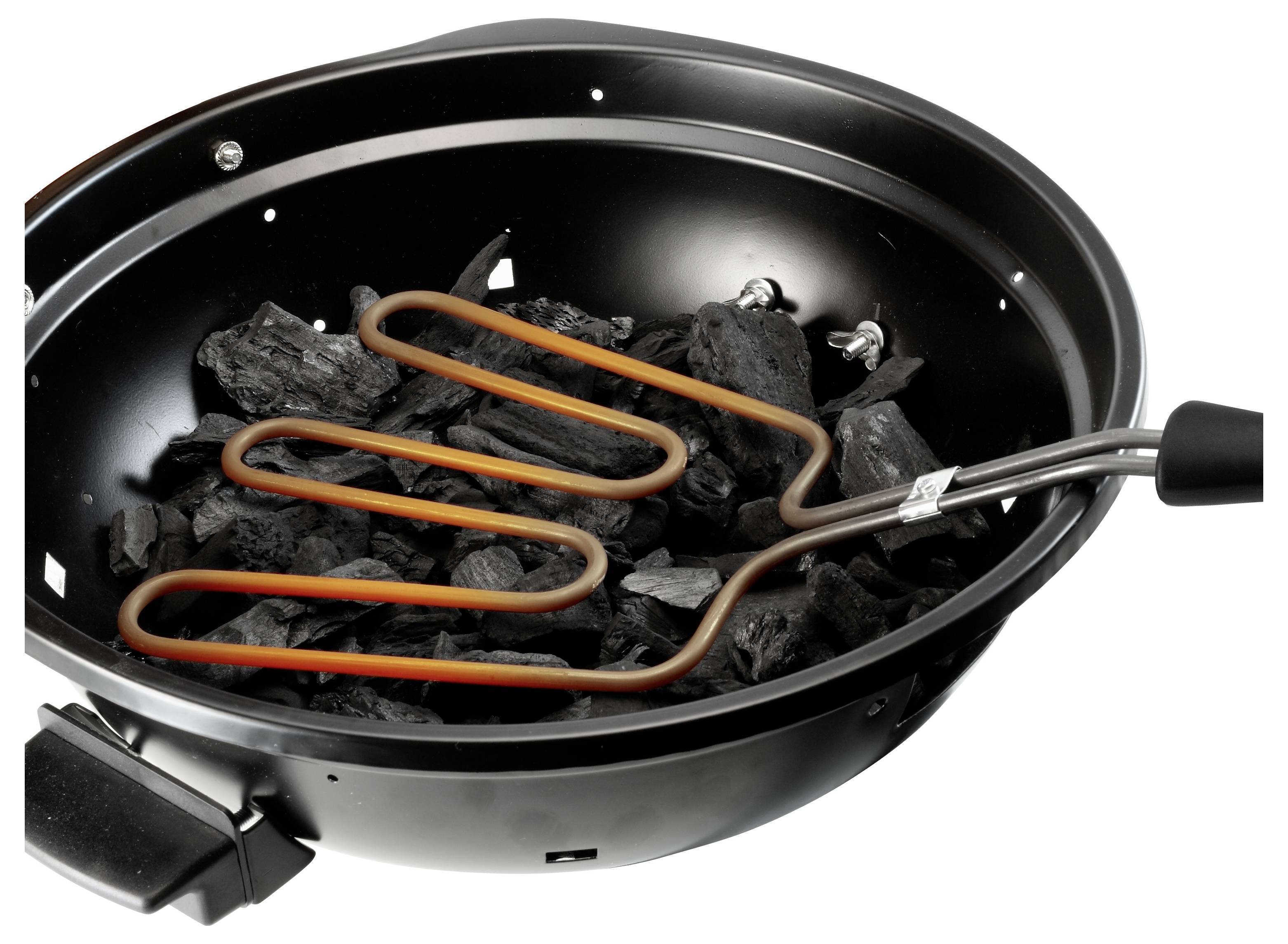 Elektrischer Holzkohlestarter mit einem spiralförmigen Heizelement, das in einer Schale mit Holzkohle ruht, wird verwendet, um Kohlen in einem Grill zu zünden.