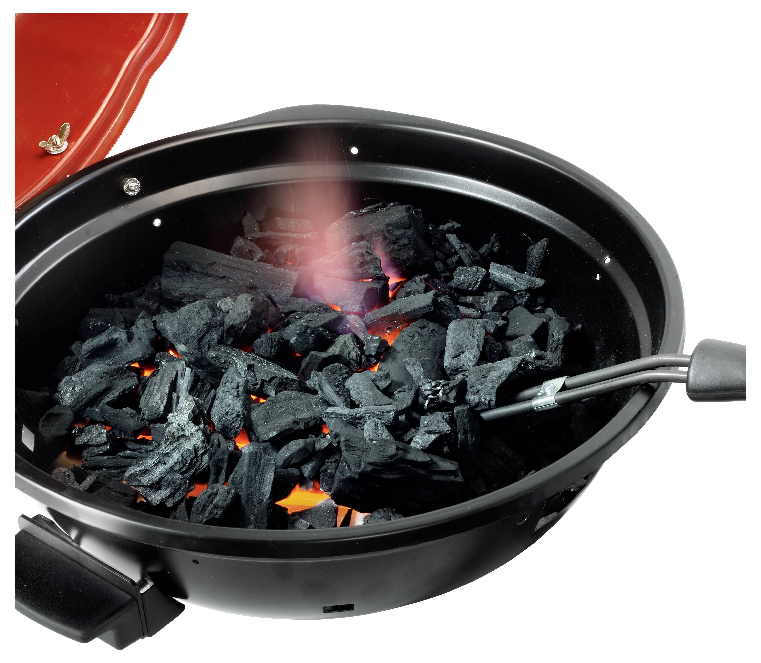 Holzkohle brennt in einem schwarzen Grillgerat, mit einem roten Deckel offen und glühenden Kohlen sichtbar im Inneren.