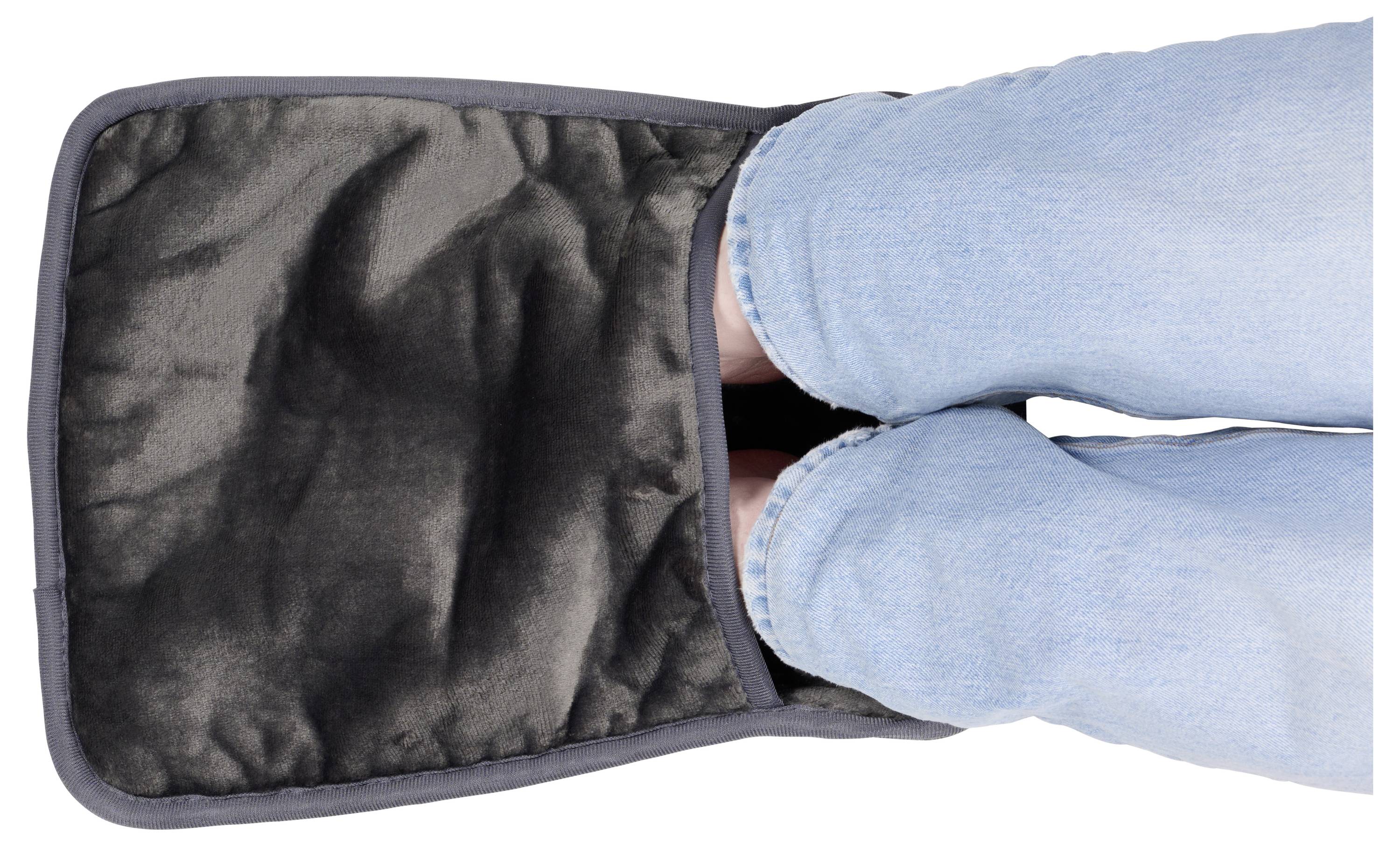 Person in blue Jeans greift in eine schwarze gefütterte Tasche oder Hülle, von oben auf weißem Hintergrund betrachtet.
