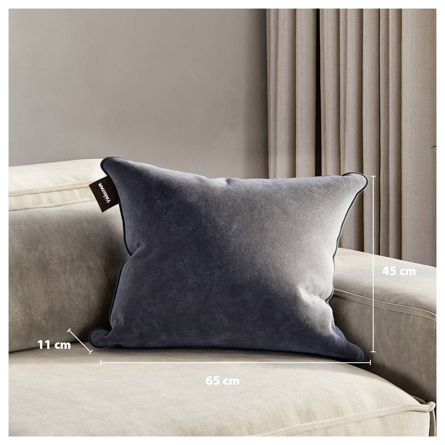 Graues rechteckiges Samtdekowissen auf einem Sofa, beschriftet mit 65 cm Breite, 45 cm Höhe und 11 cm Tiefe.