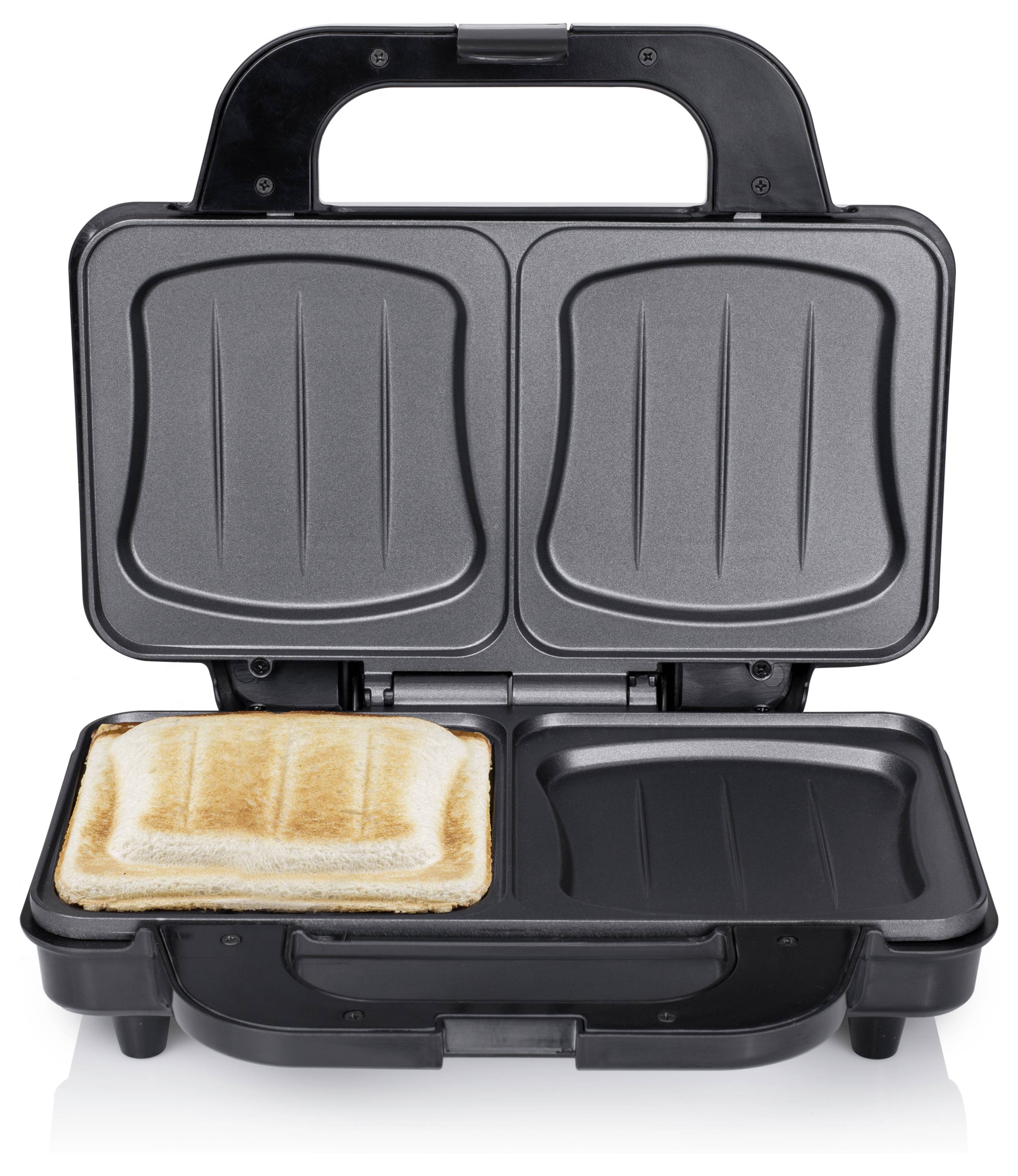 Offene schwarze Sandwichpresse mit einer Scheibe geröstetem Brot auf der unteren linken Platte und angehobenem Deckel, der zwei Kochplatten zeigt.