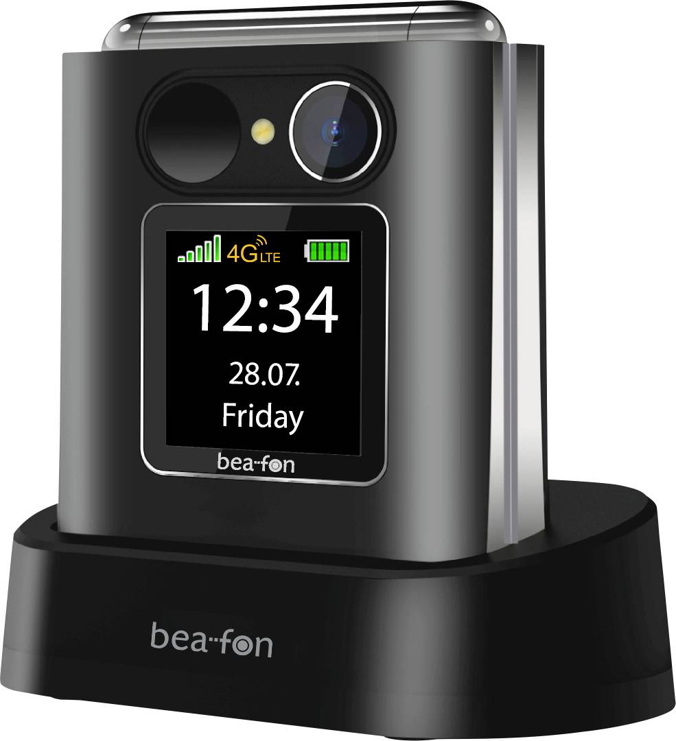 Eingeklapptes Klapphandy auf Ladedock, zeigt Vorderbildschirm mit Uhrzeit 12:34, Datum 28.07., Freitag, 4G LTE Signal und Batteriesymbole.