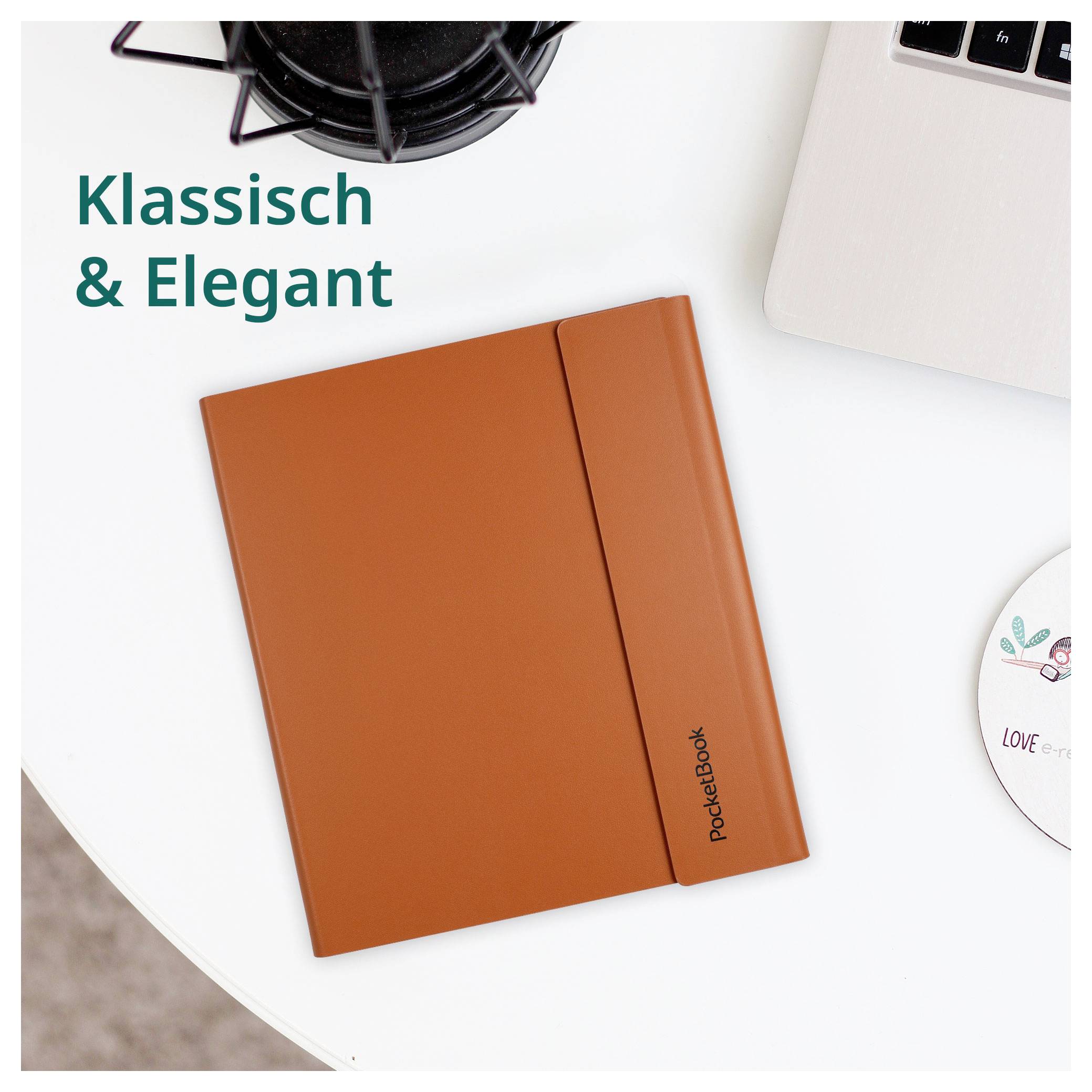 Orange PocketBook Notizbuch auf einem weißen Schreibtisch mit einem Laptop und einer Kaffeetasse; Text sagt „Klassisch & Elegant