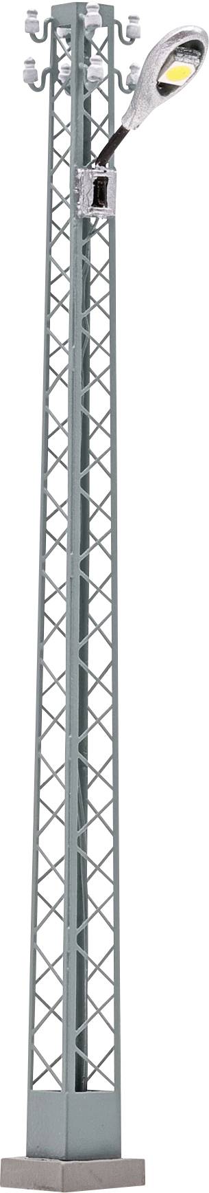 Hoher grauer Metallmast oder Mobilfunkmast mit Gitterseiten, Schrank an der Basis und einer Straßenleuchte in der Nähe der Oberseite angebracht.