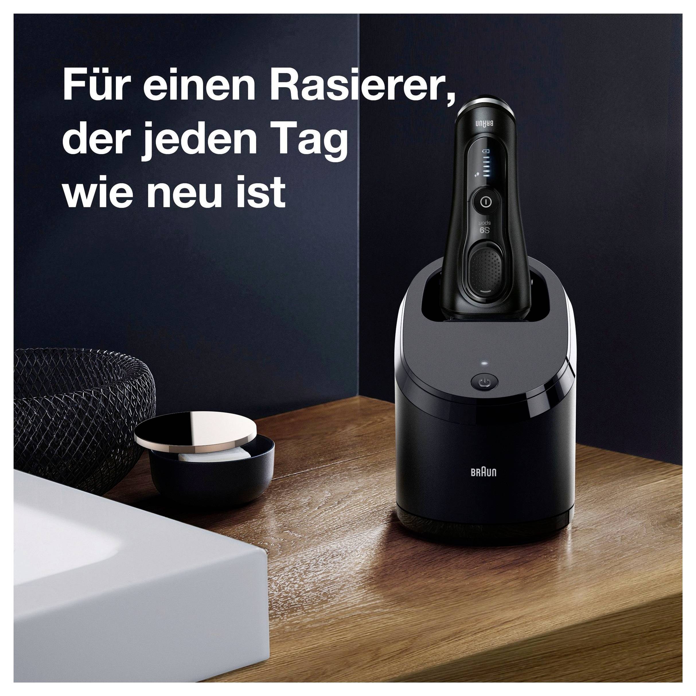 Braun Elektrorasierer in einer Lade-/Reinigungsstation auf einer Holzoberfläche, mit deutschem Text: „Für einen Rasierer, der jeden Tag wie neu ist