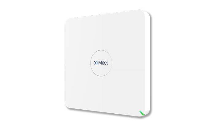 Weiß montiertes Mitel-Wandkommunikationsgerät mit zentriertem Logo und kleiner grüner Statusleuchte unten rechts.