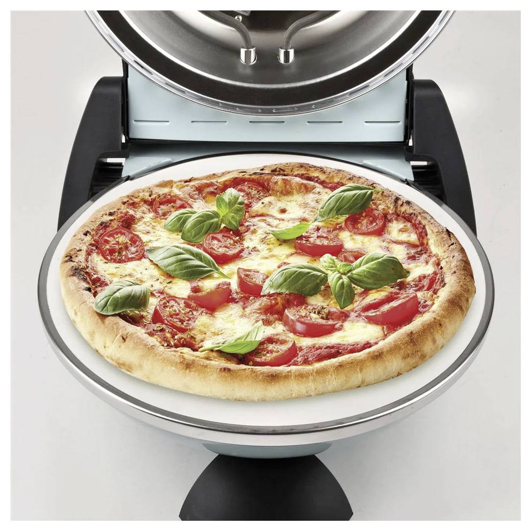 Pizzabacken in einem Tischbackofen, mit einer Tomaten- und Basilikum-Pizza auf einem rotierenden Tablett.