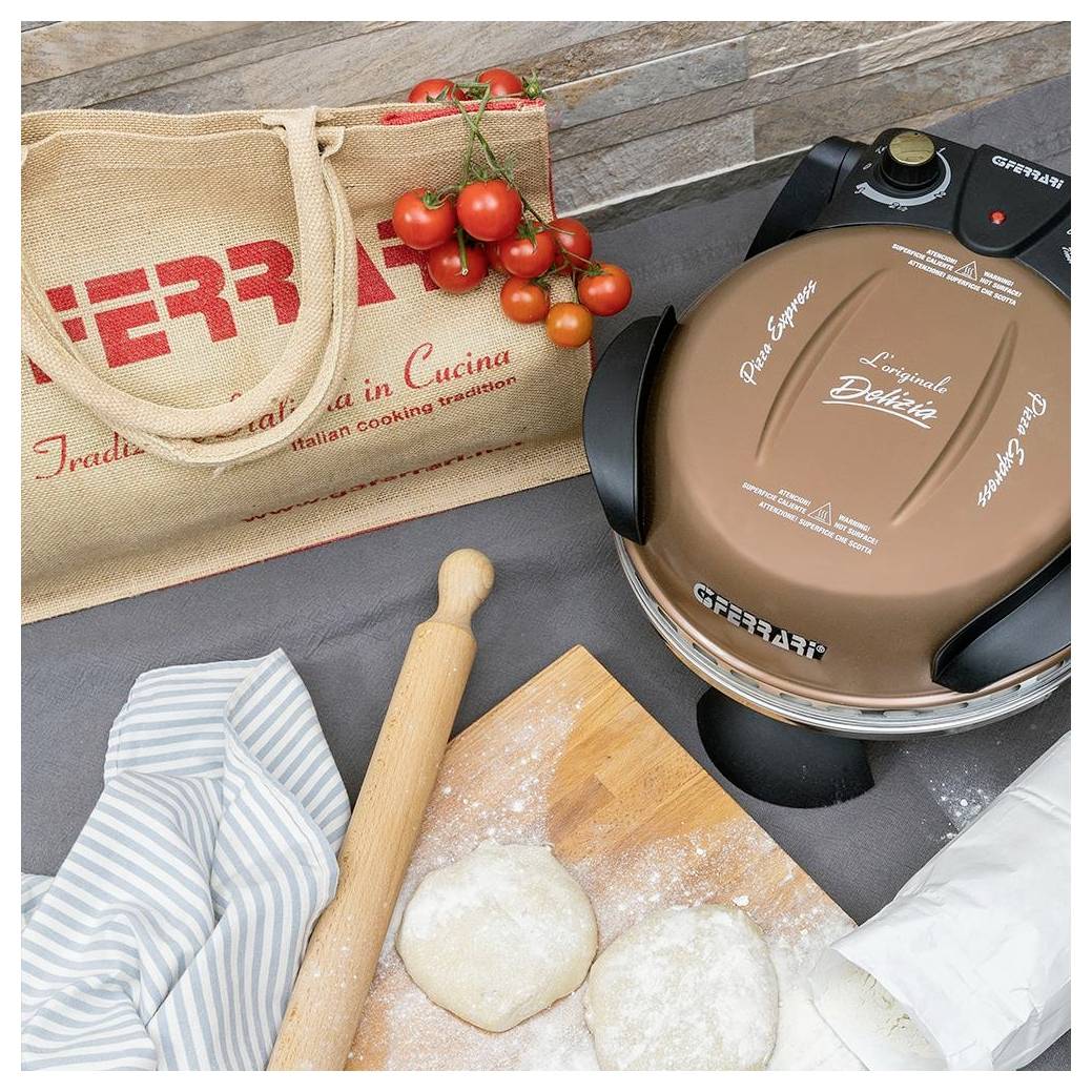 Bäckers Ausstattung mit einem G3 Ferrari Pizzaofen, Teig auf einem bemehlten Brett, Nudelholz, Tuch, Kirschtomaten und einer wiederverwendbaren Tasche.