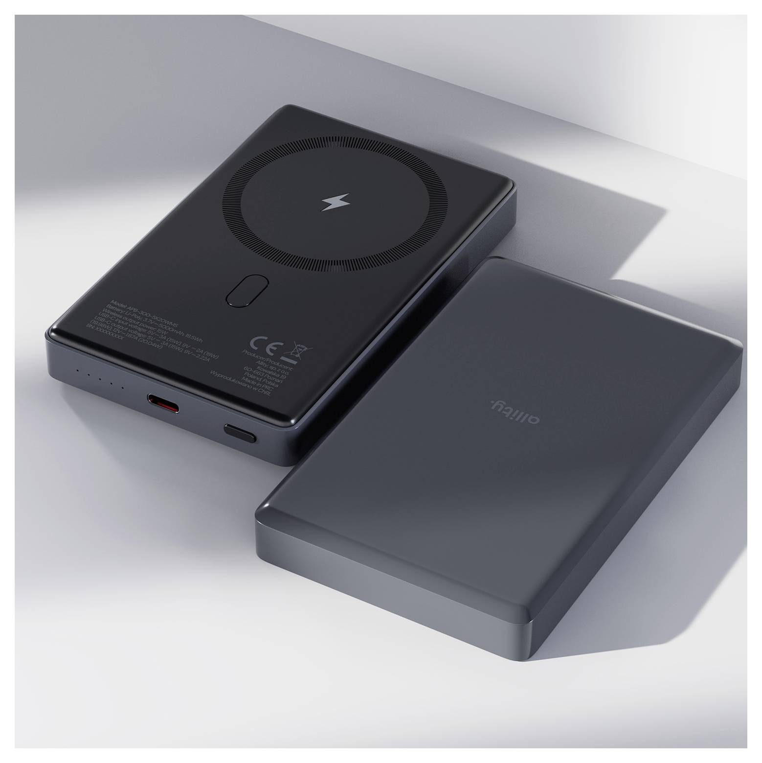 Zwei schlanke schwarze tragbare Ladegeräte gezeigt, eine Vorderansicht mit drahtlosem Ladepad und USB-C-Anschluss, eine Rückansicht mit einem Logo.