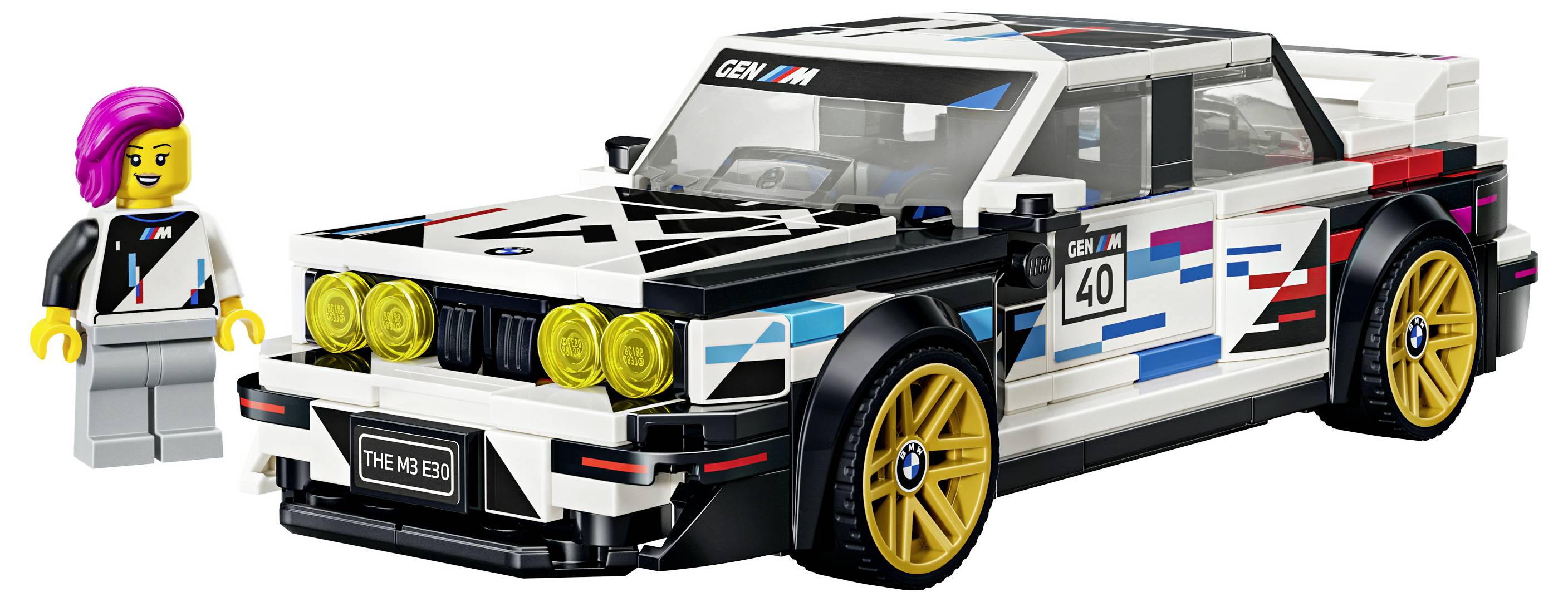 LEGO-ähnliches BMW-Rennwagen-Modell mit goldenen Rädern und vier gelben Scheinwerfern, dargestellt neben einer Minifigur-Fahrerin auf weißem Hintergrund.