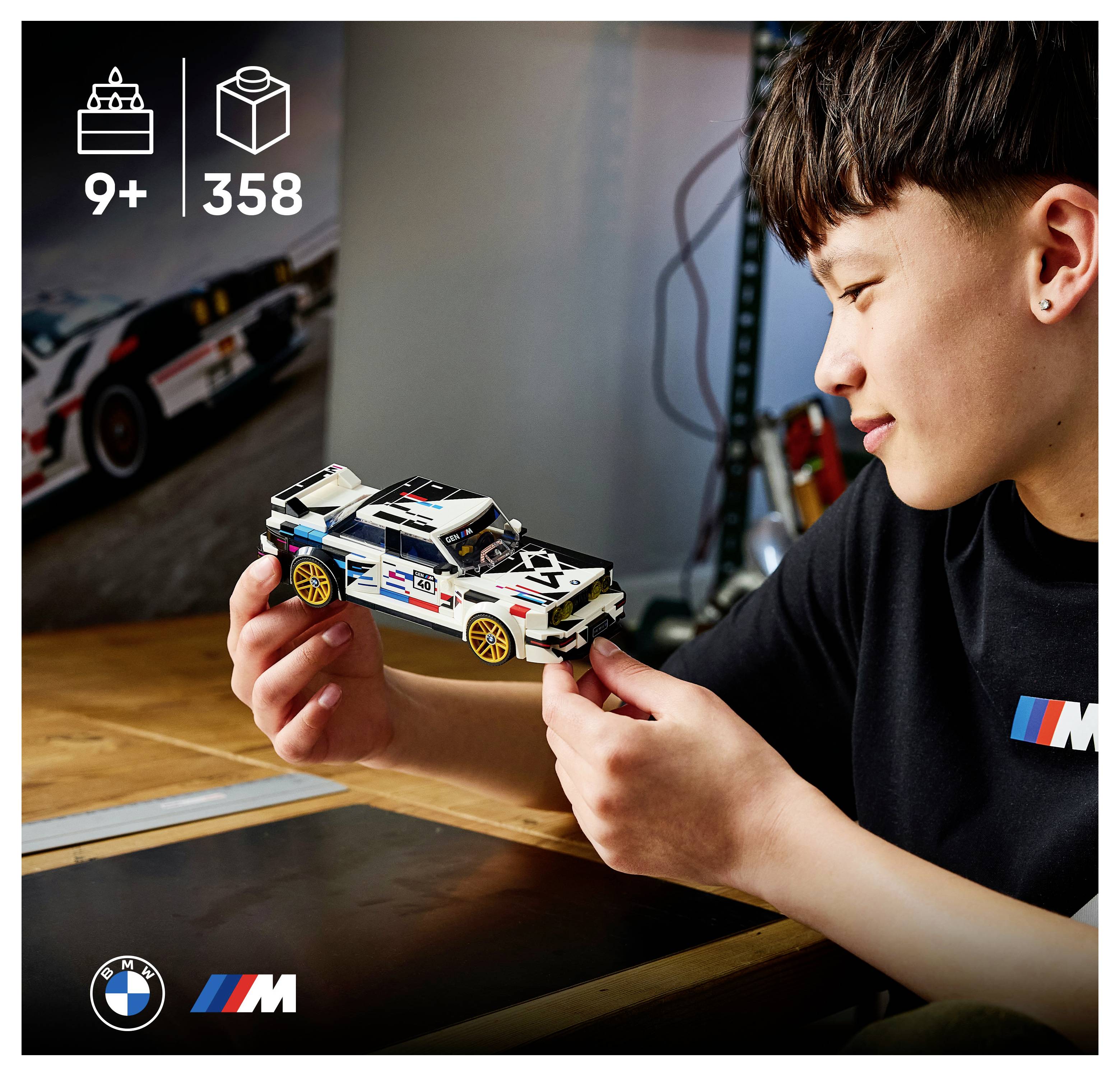 Ein Junge hält und bewundert ein LEGO BMW M Rennwagen-Modell; das Bild zeigt eine Altersfreigabe ab 9 Jahren und 358 Teile.