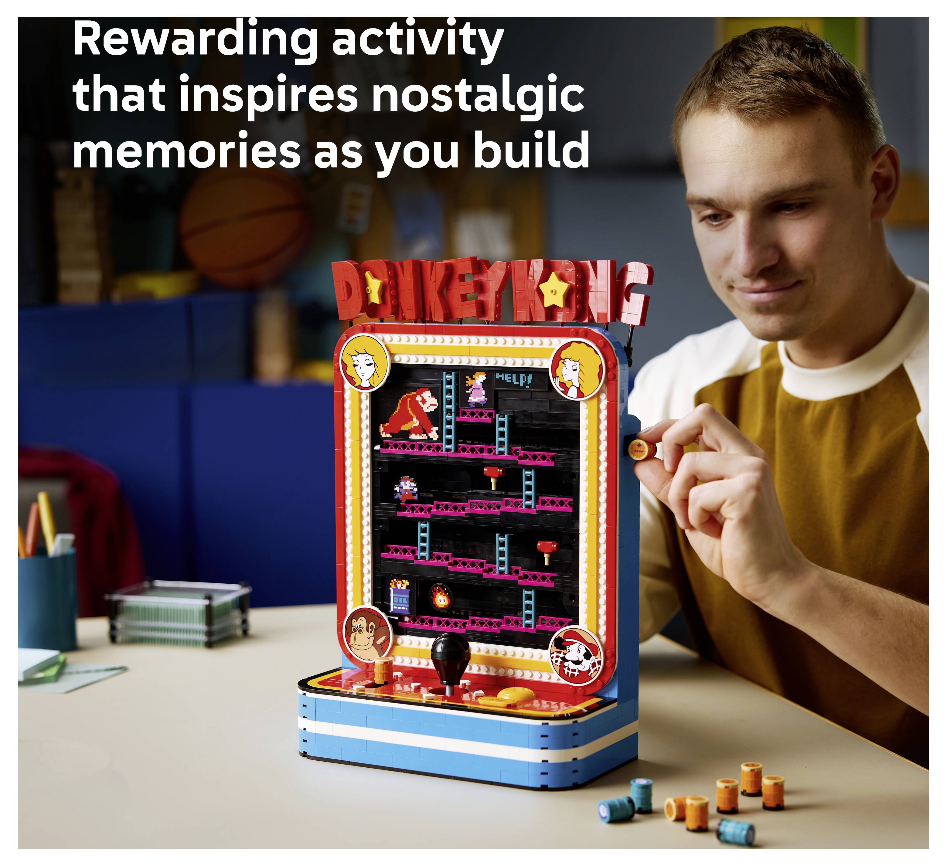 Mann spielt ein Tabletop-Donkey-Kong-Arcade-Spiel mit der Bildunterschrift „Befriedigende Aktivität, die nostalgische Erinnerungen weckt, während du baust