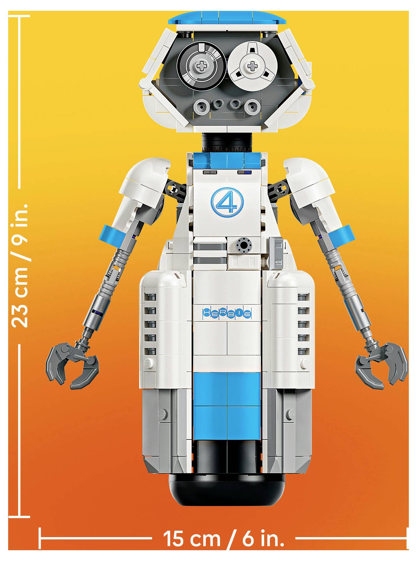 Frontansicht einer LEGO-ähnlichen Roboterfigur mit Krallenhänden auf orangefarbenem Hintergrund, gekennzeichnet als 23 cm/9 Zoll groß und 15 cm/6 Zoll breit.