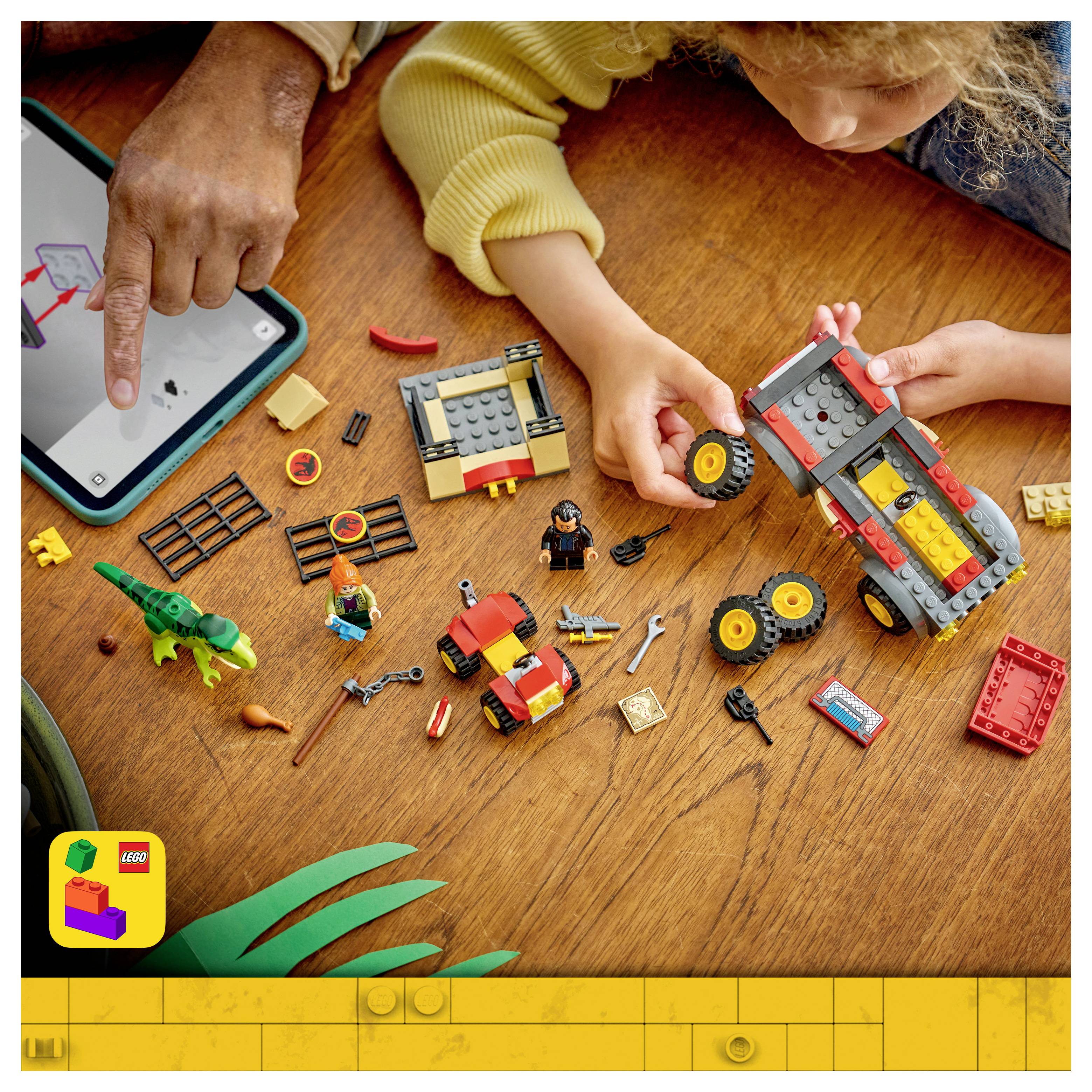 Ein Kind und ein Erwachsener bauen gemeinsam ein LEGO-Fahrzeug auf einem Holztisch auf, während sie ein Tablet mit Anleitung verwenden. In der Nähe sind verstreute LEGO-Teile und Figuren zu sehen.