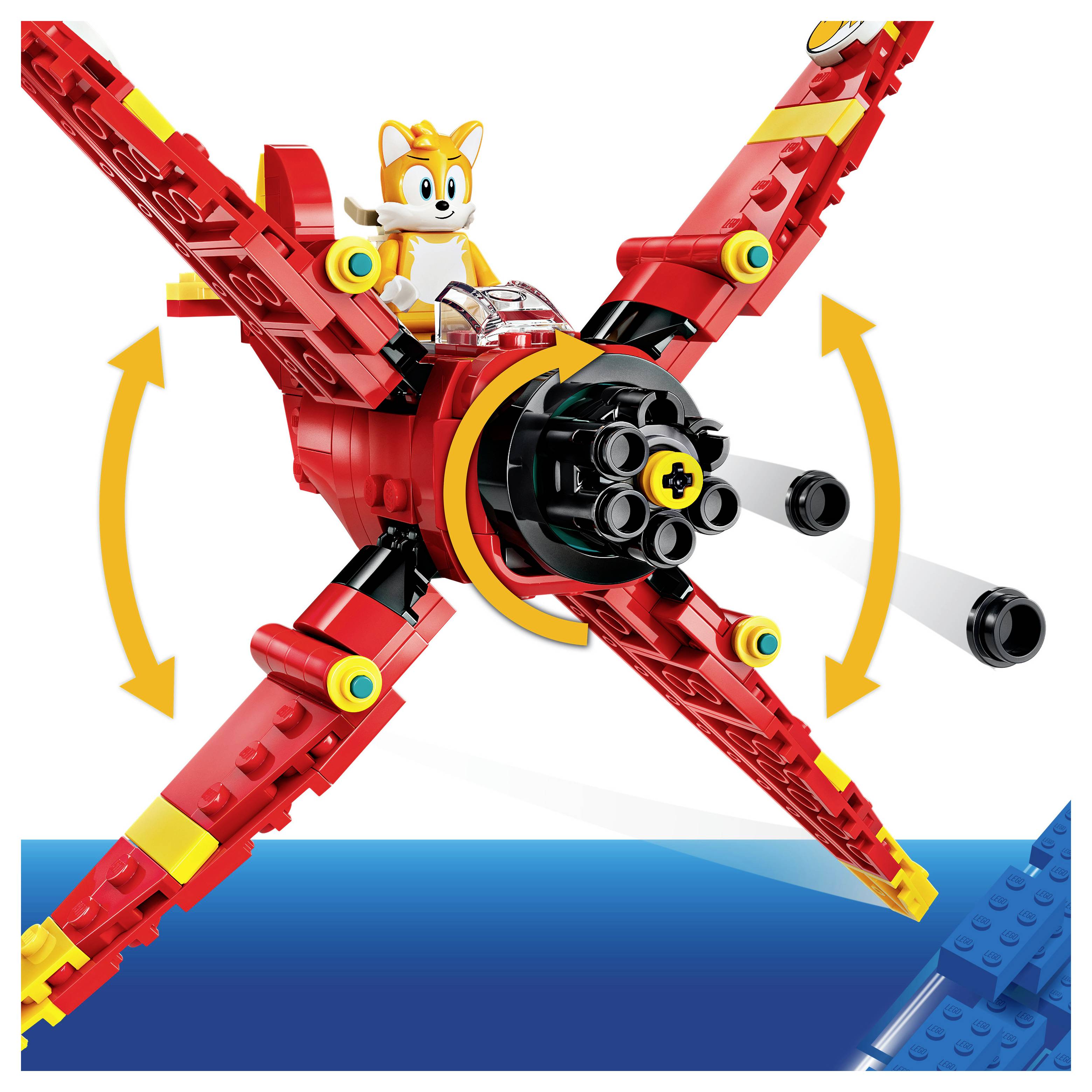 LEGO-Stil rotes Flugzeug mit Tails-Figur, zeigt sich drehenden Propeller und faltbare Flügel, die durch Pfeile angedeutet sind.