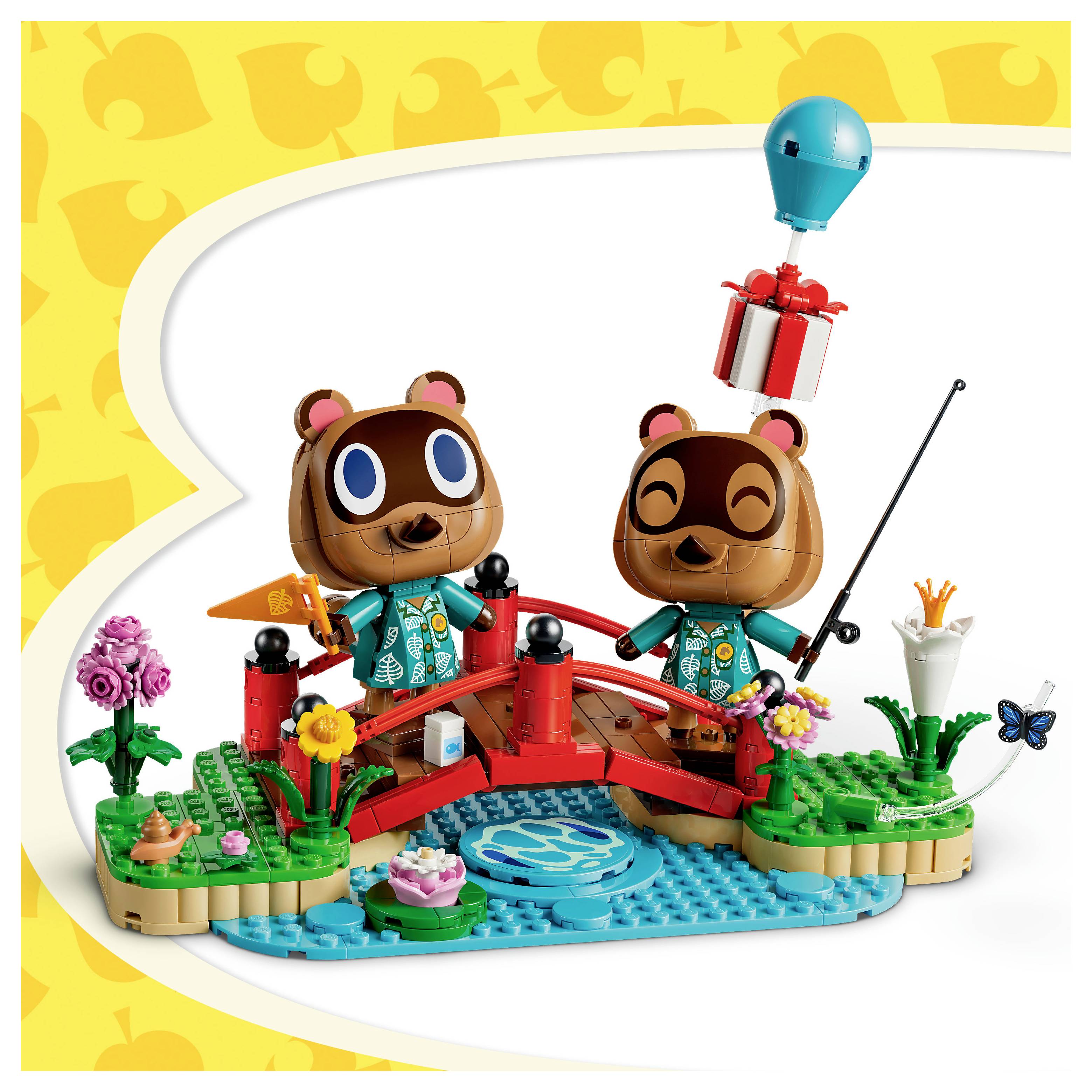 Zwei lächelnde Spielzeugbären auf einer kleinen roten Brücke über blauem Wasser, mit Blumen, einer Angelrute und einem Geschenkballon in einer verspielte LEGO-artigen Szene.
