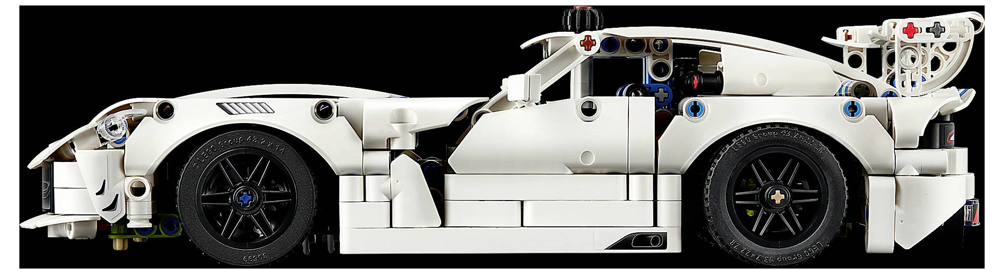 Seitenansicht eines weißen LEGO-ähnlichen Rennwagen-Modells mit freigelegten schwarzen Rädern und detaillierten mechanischen Teilen vor schwarzem Hintergrund.