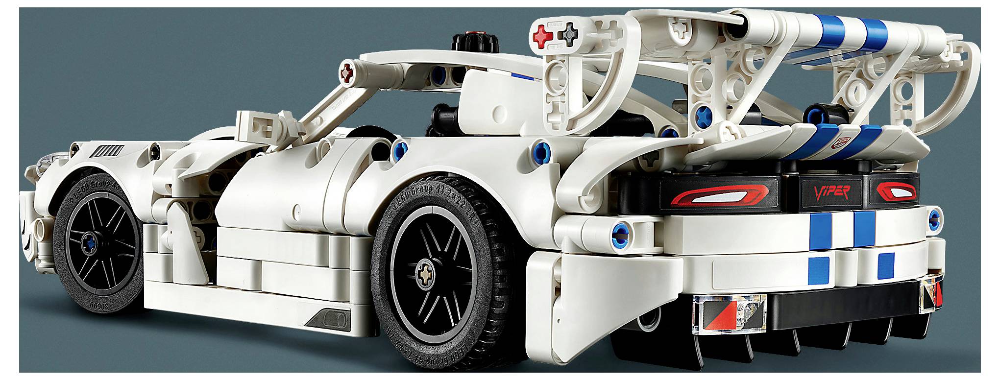 Rückansicht eines weißen LEGO-ähnlichen Rennwagens mit freiliegentem, blau akzentuiertem Hinterrahmen, großen Rädern und 