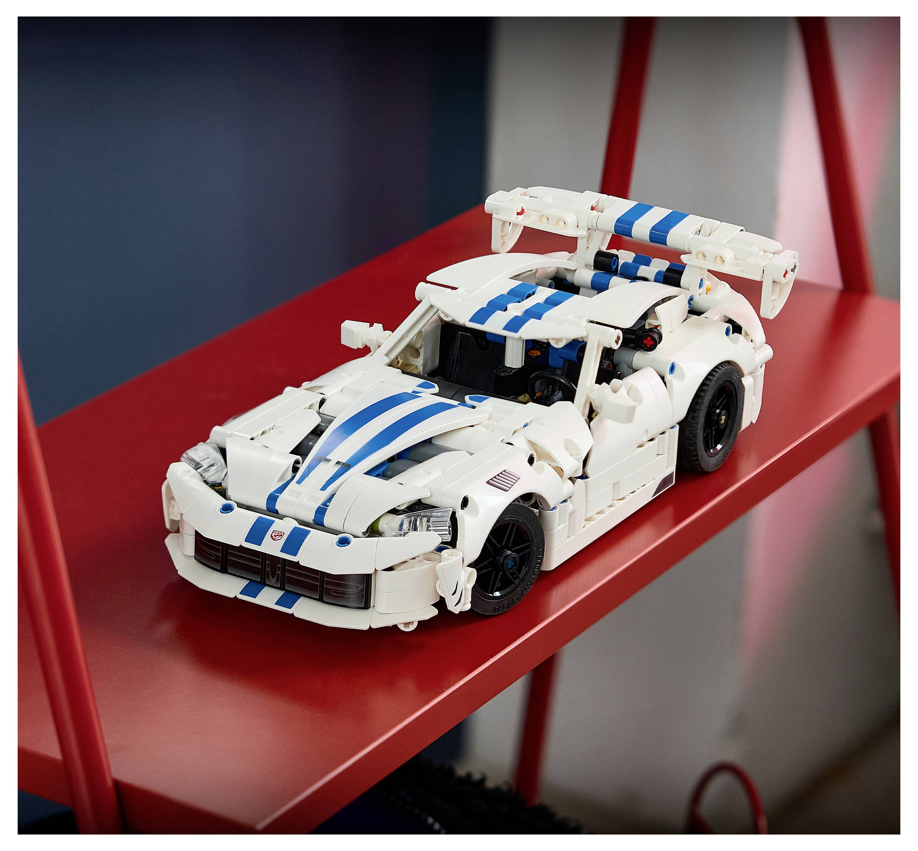 Weißes LEGO-Rennwagen mit blauen Streifen auf einem roten Regal, in Dreiviertelsicht gezeigt.