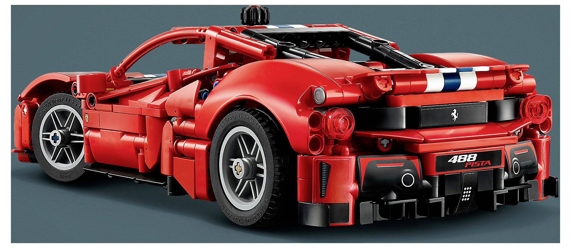 Heckansicht eines roten Ferrari 488 Pista Sportwagens, dargestellt in einem studioähnlichen Bild mit schwarzen Rennstreifen und sichtbaren Heckdetails.