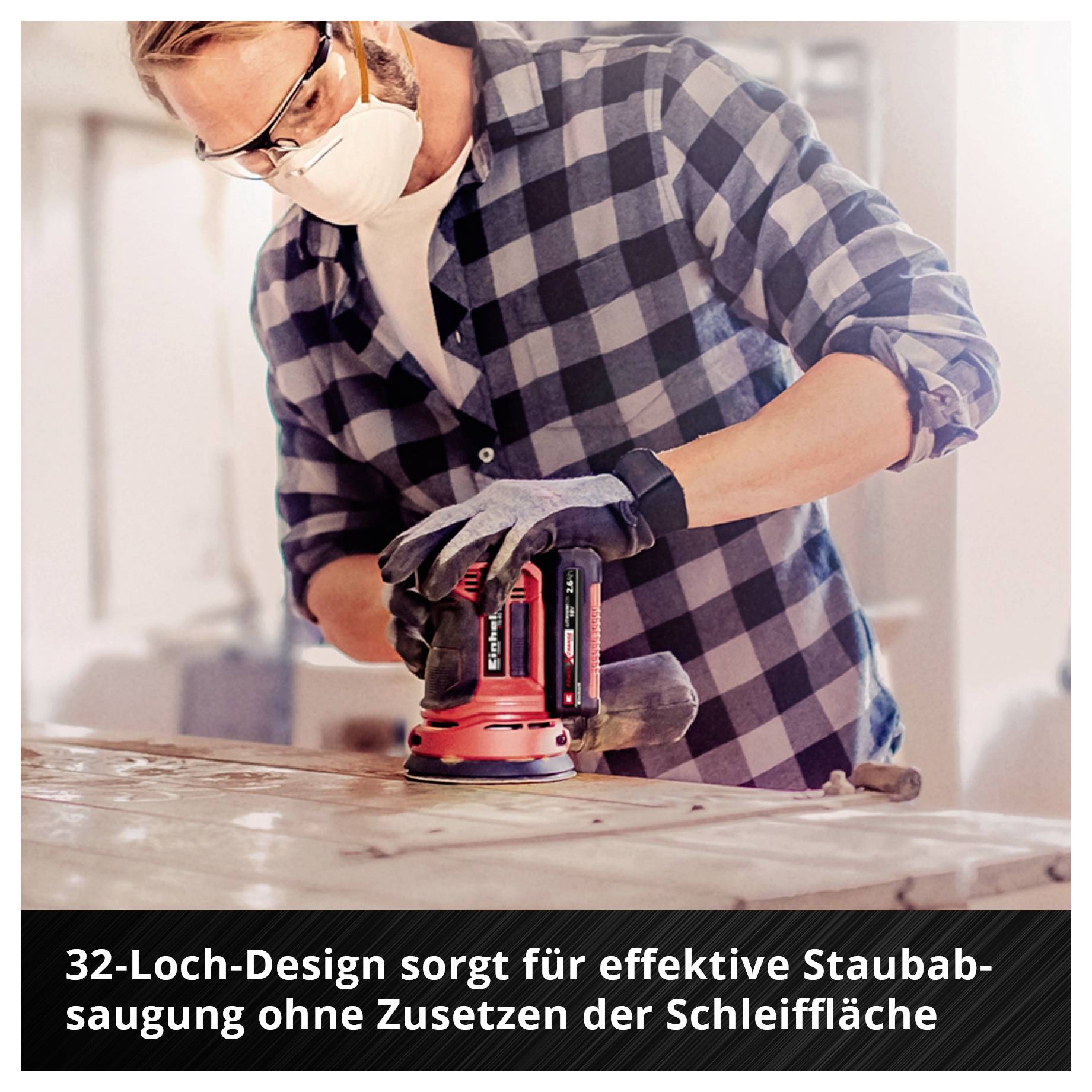 Mann mit Schutzbrille und Atemmaske schleift Holz mit einem roten Exzenterschleifer; Text: '32-Loch-Design sorgt für effektive Staubabsaugung ohne Zusetzen der Schleiffläche'