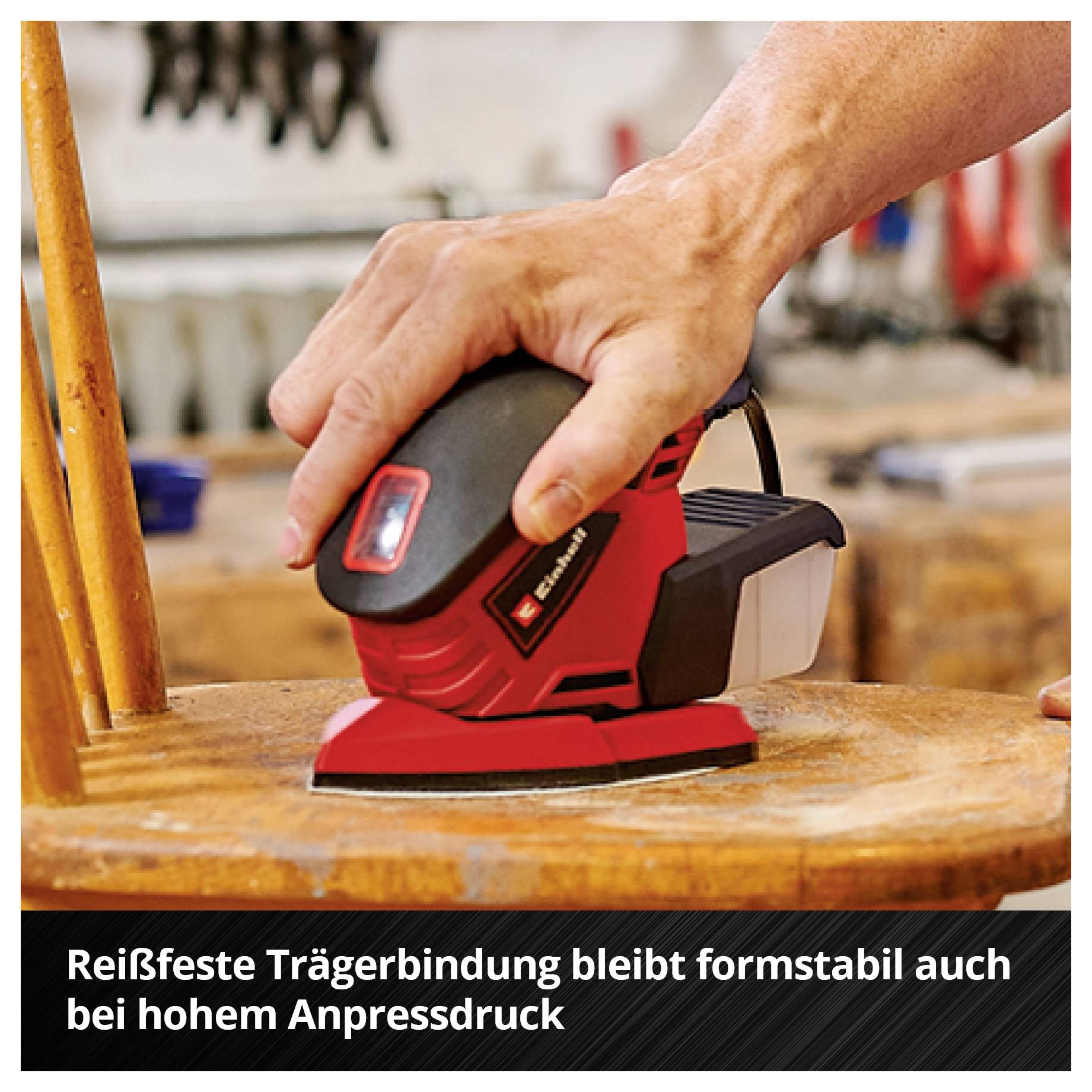 Hand schleift mit einem roten Schwingschleifer eine Holzoberfläche; darunter steht: 'Reißfeste Trägerbindung bleibt formstabil auch bei hohem Anpressdruck'.